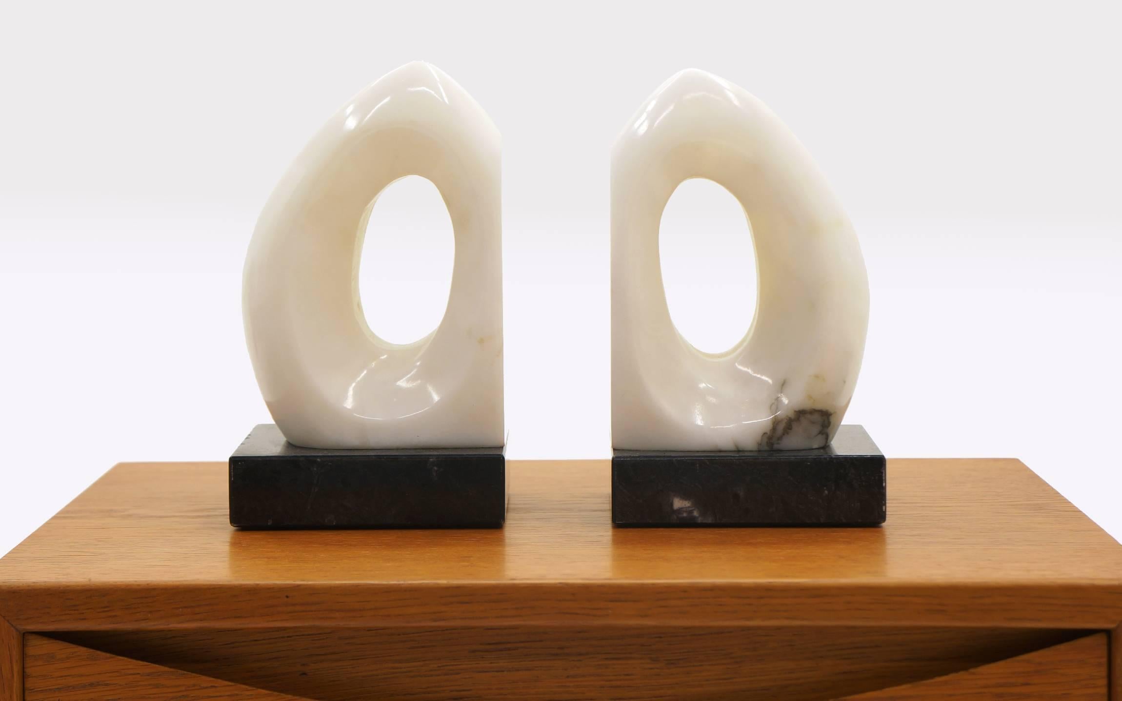 Pair of bookends, sculptural, organic alabaster forms on black marble bases. Excellent condition. Numbered and signed 