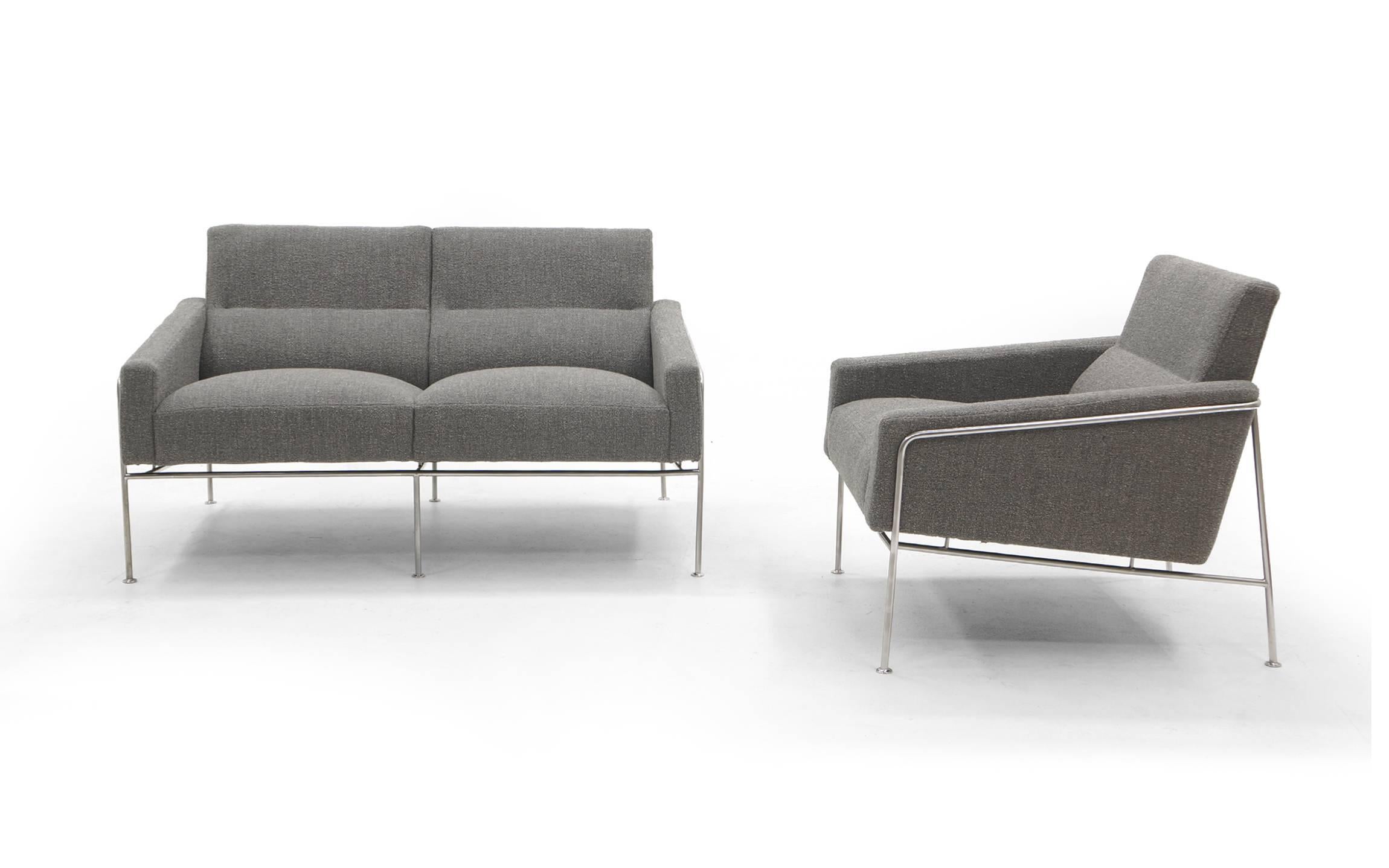 Two-seat sofa settee and chair designed by Arne Jacobsen for the SAS airport in 1957 and manufactured by Fritz Hansen, Denmark. These early examples have been fully restored and reupholstered in a soft medium gray / light charcoal grey maharam
