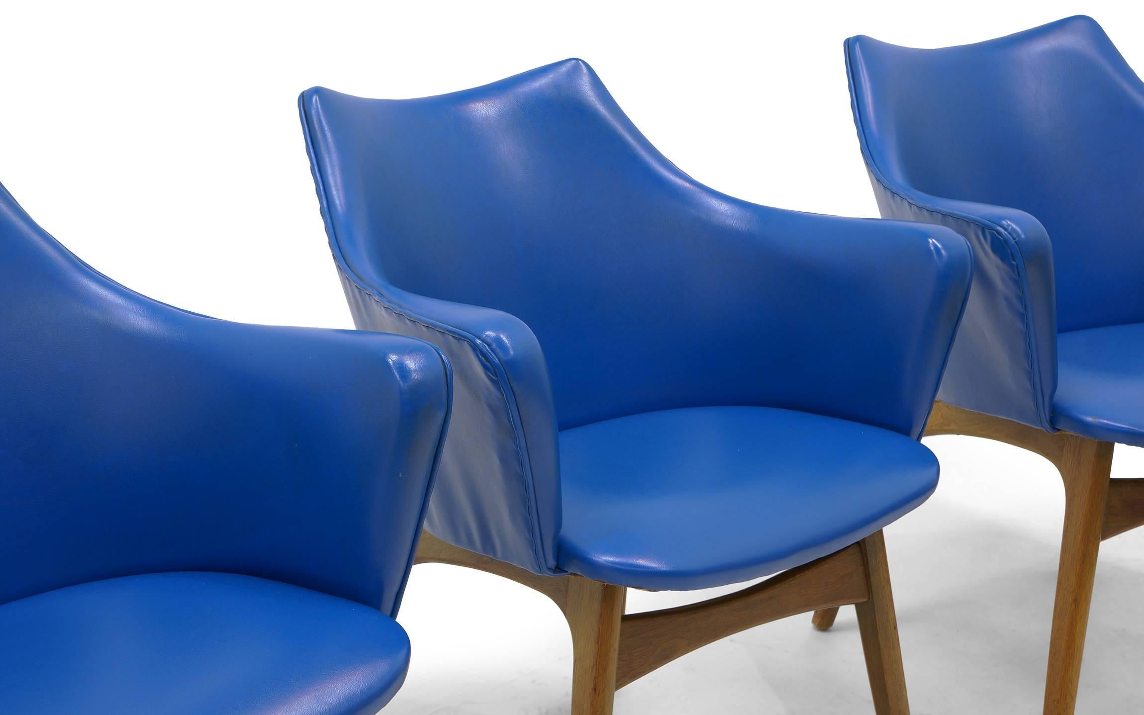 Set of four dining chairs designed by Adrian Pearsall for Craft Associates. Walnut legs and blue vinyl upholstery. The vinyl is in very good condition but is loose in areas around the sides and backs of the chairs. They are ready to use as is, but