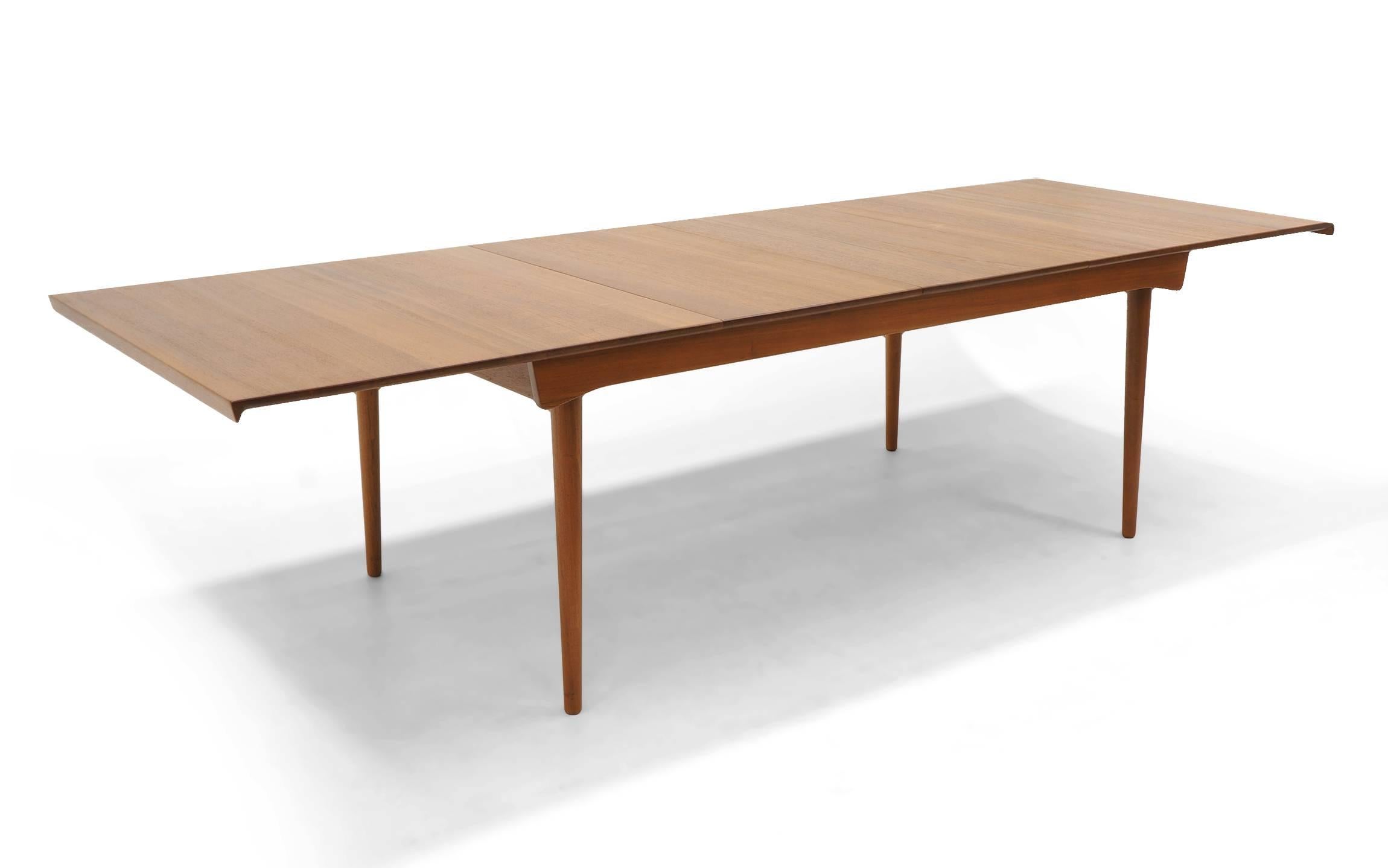 Teak dining table designed by Finn Juhl, arguably the best designer of Danish modern furniture. Ingenious design in that the table top floats on the base allowing expansion to take place without the legs moving. In addition, the two leaves easily