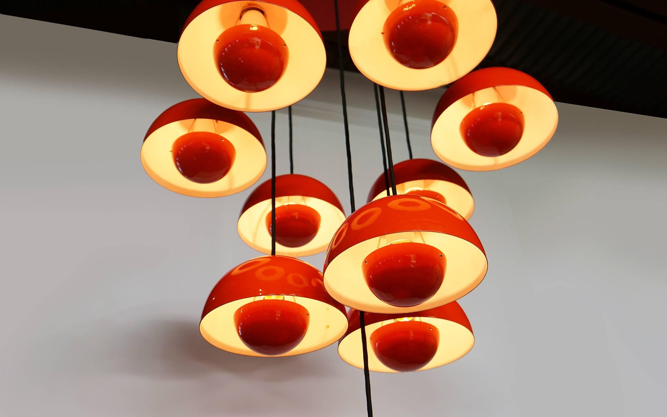 A cluster of ten vintage Verner Panton for Louis Poulsen, Denmark, Flowerpots in red/orange enamel, mounted according to the original specifications on a red painted ceiling plate. All of the lamps are vintage originals with real glass enamel. There