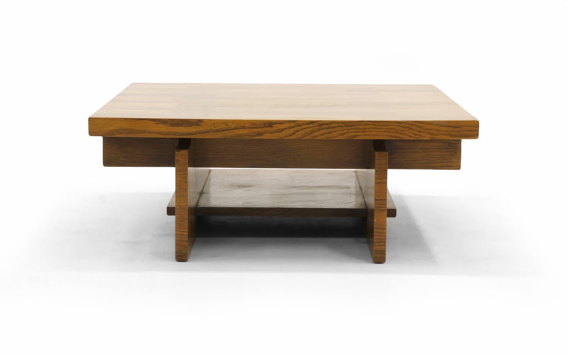 Lane coffee table. Interesting architectural construction with magazine / book storage on a lower shelf. Excellent details with the patterned walnut veneers. The is a very sturdy, well constructed table. Strong enough to sit on or put ones feet up.