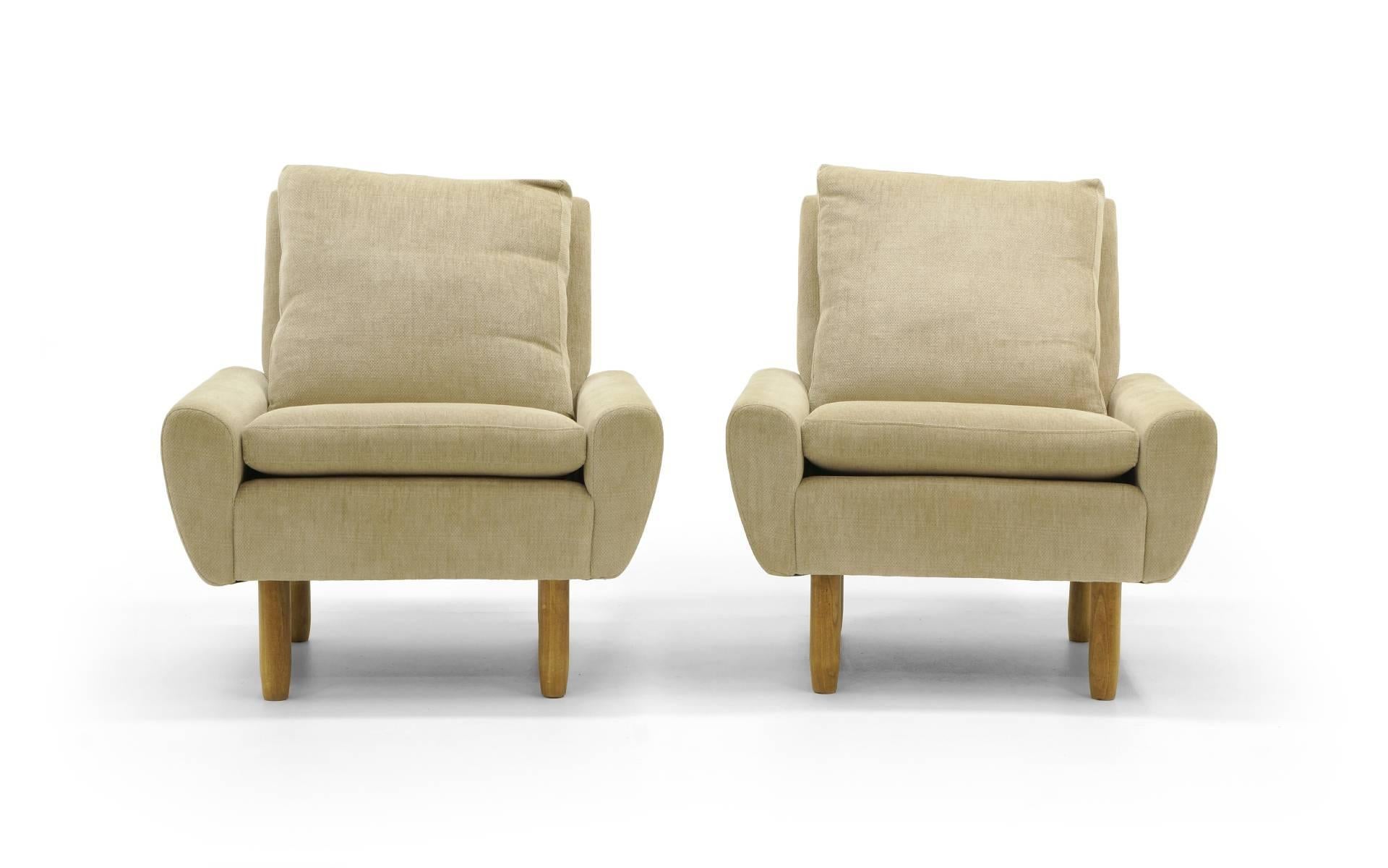 Pair of fully upholstered Danish modern lounge chairs in a neutral cream fabric. Very comfortable.