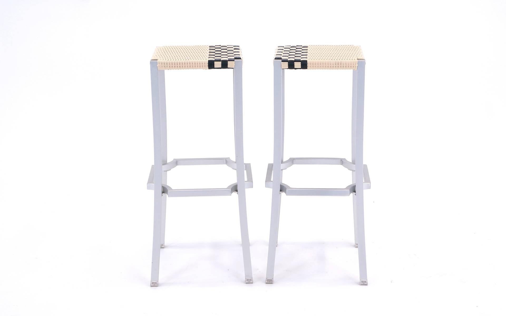 Pair of never used One Cafe bar stools designed by Philippe Starck in 2006 for Driade, Italy. The stool structure is sandblasted anodized polished aluminium with seat in woven plastic in ivory and black. It can be used indoor as well as outdoor.