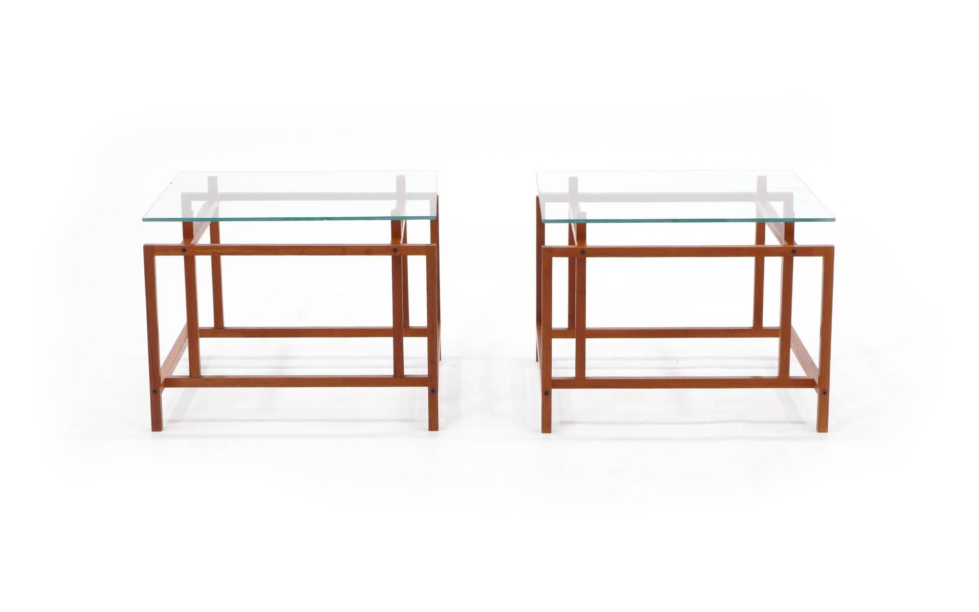 Beautiful pair of teak side tables with original glass tops. The glass doesn't just sit on the base. Brass pegs extend out of the base at four points on each table and insert into 1/8