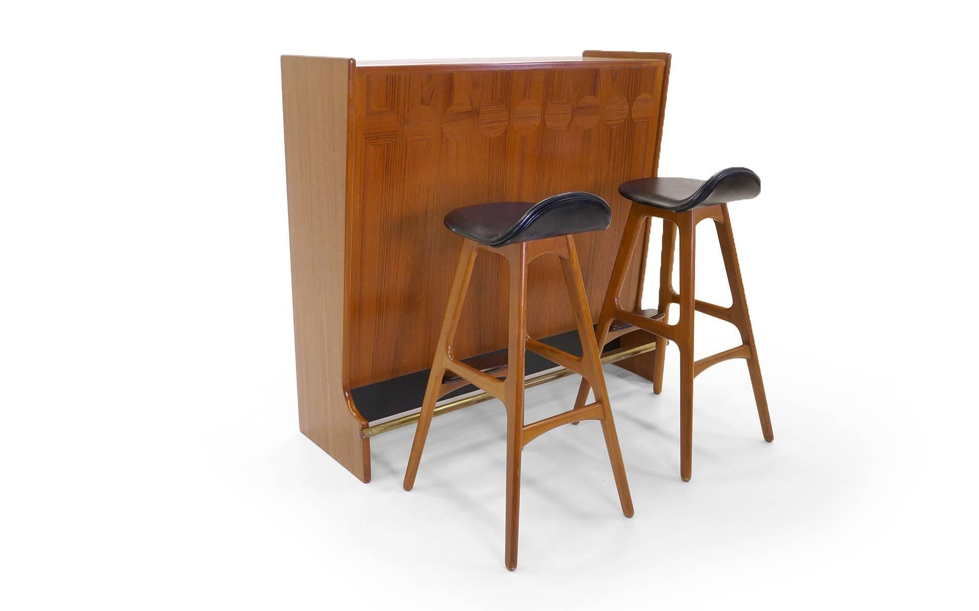 Amazing 1960s teak bar by Johannes Anderson for Skanning and Son, Denmark, with two Erik Buch bar stools with teak frames and rosewood footrests. Everything is in very good original condition. The original stool seats have some wear, but no tears or