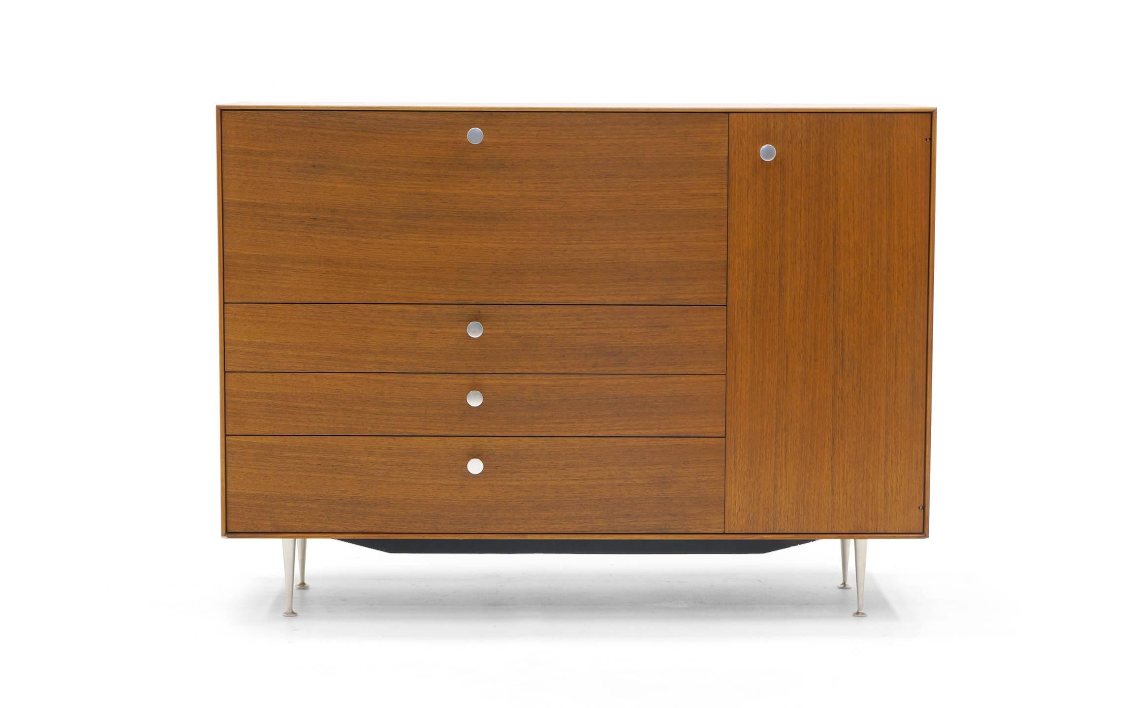 George Nelson for Herman Miller Thin Edge Secretary. Walnut case with case aluminum legs and pulls. Porcelain pulls on the small drawers concealed behind the leather covered drop down desk top. This is an exceptional example of this versatile