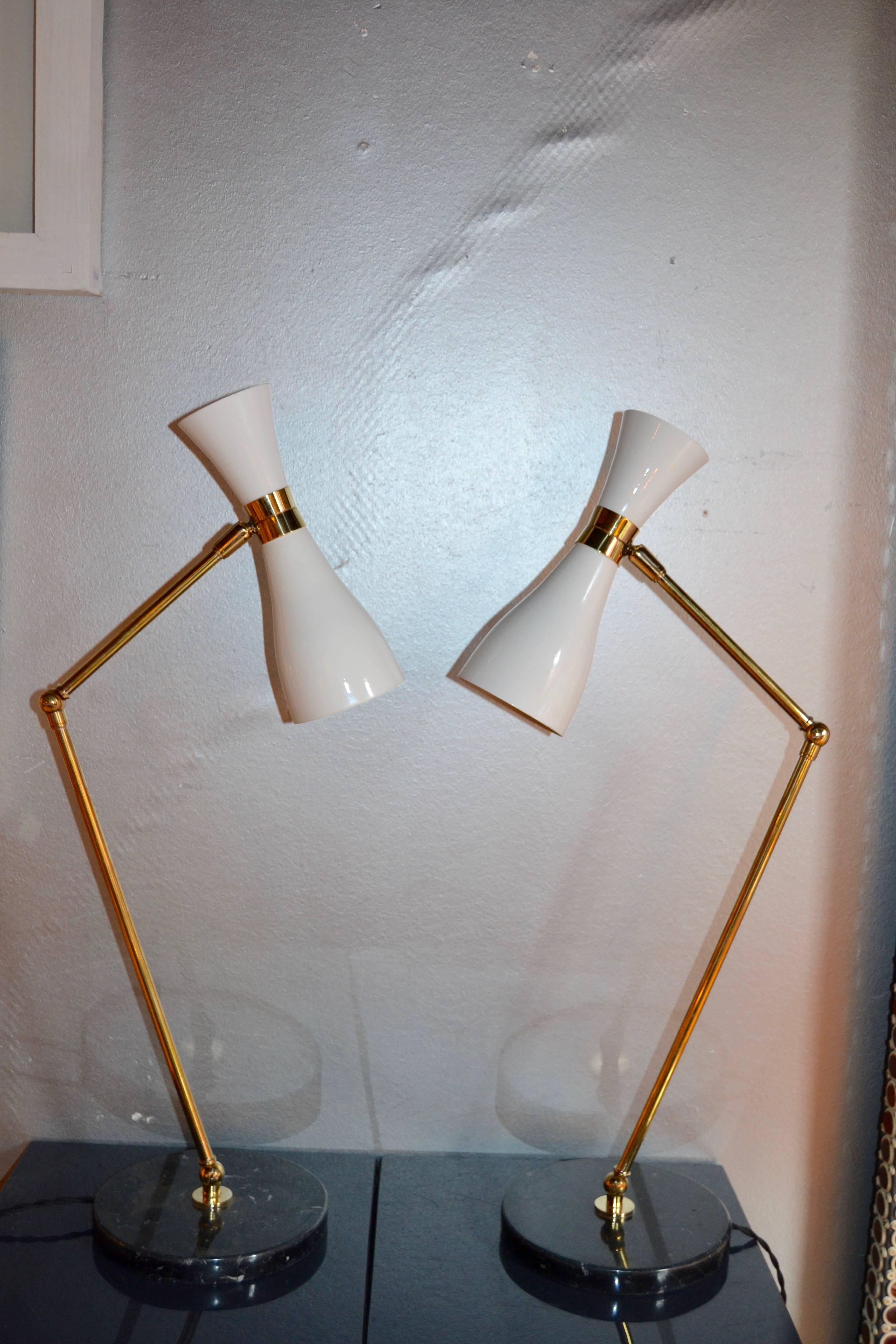 Pair of Italian 1970-1980s lamps with black white veined marble round base. 
Lamp is compose by three swivels to be adjusted in height and rotating metal shade painted on white.
The shade has two bulbs on each side creating a nice light