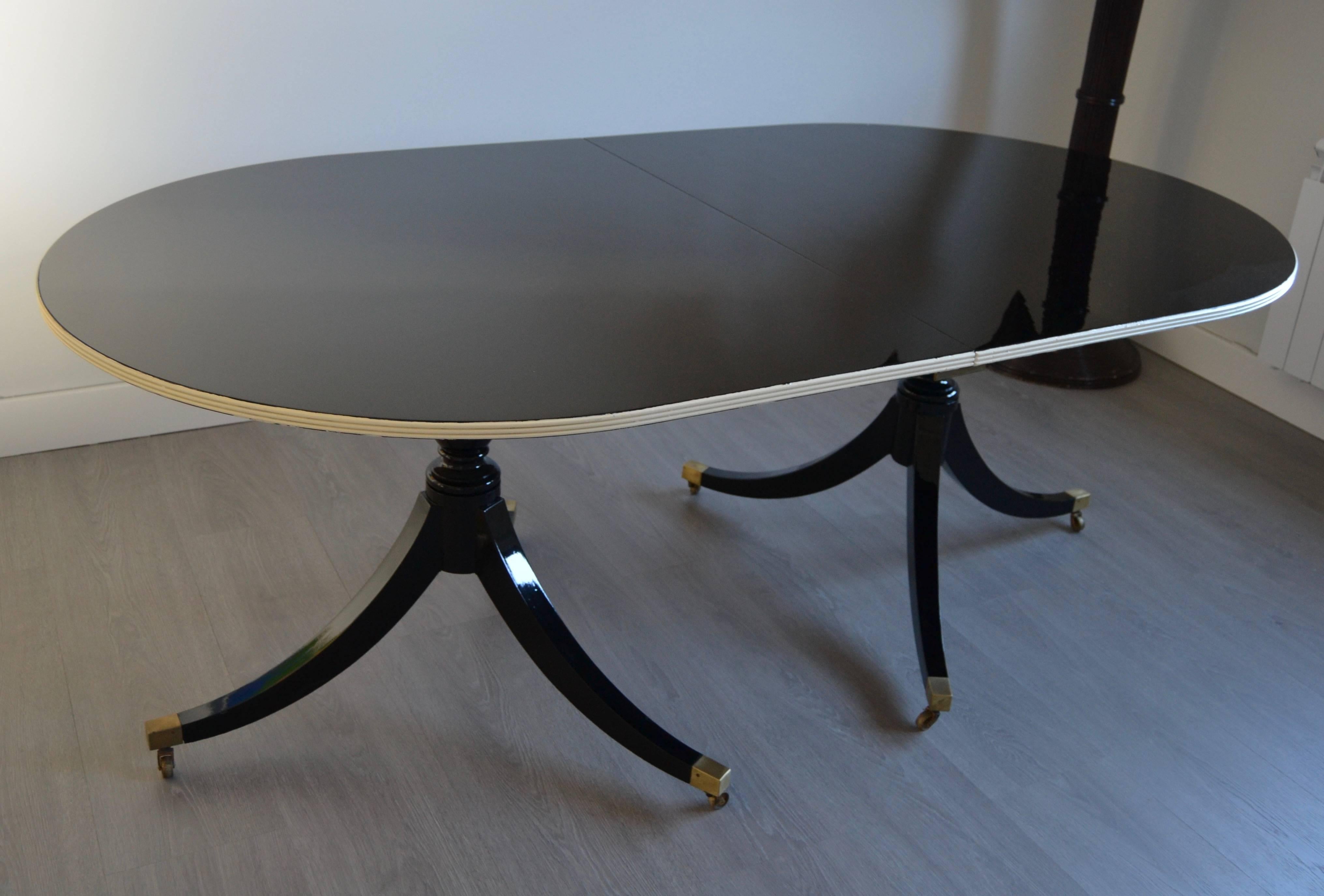 1950s mahogany black relacquered top and feet with yvory edge oval table by Mason Jansen. The table is signed by Jansen under top surface and 
bronze detailm and small wheels.
One extension leaf of 50 cm. Set on casters.
Documented on Jansen Book by