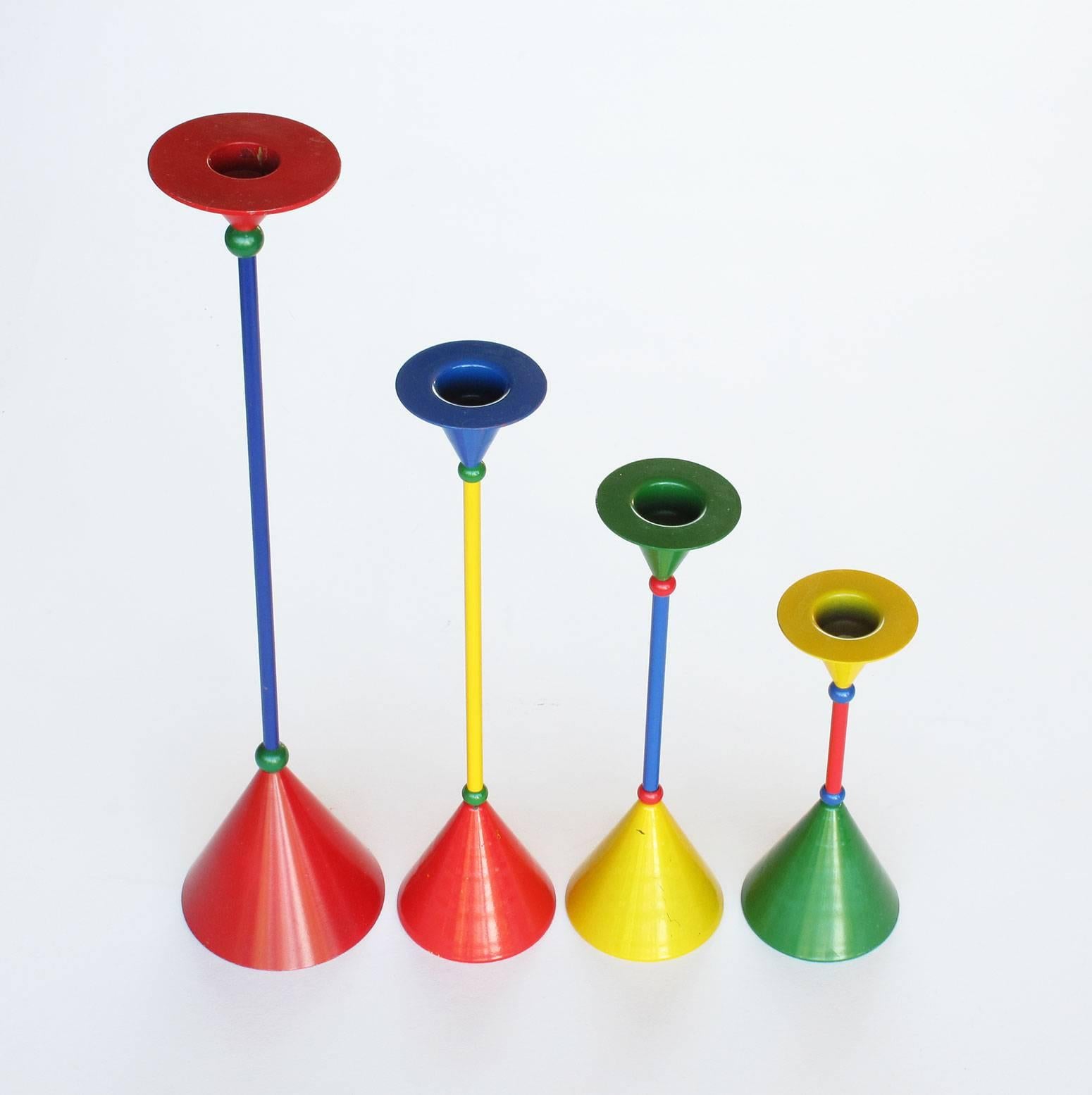 Fun collection of four multicolored vintage candlesticks in the style of Memphis Milano, metal and paint, late 1980s, Romania, dimensions from tallest to shortest in inches: (1) 13.25 high x 3 base diameter, (2) 10 x 2.5 base diameter, (3) 8 x 2.5