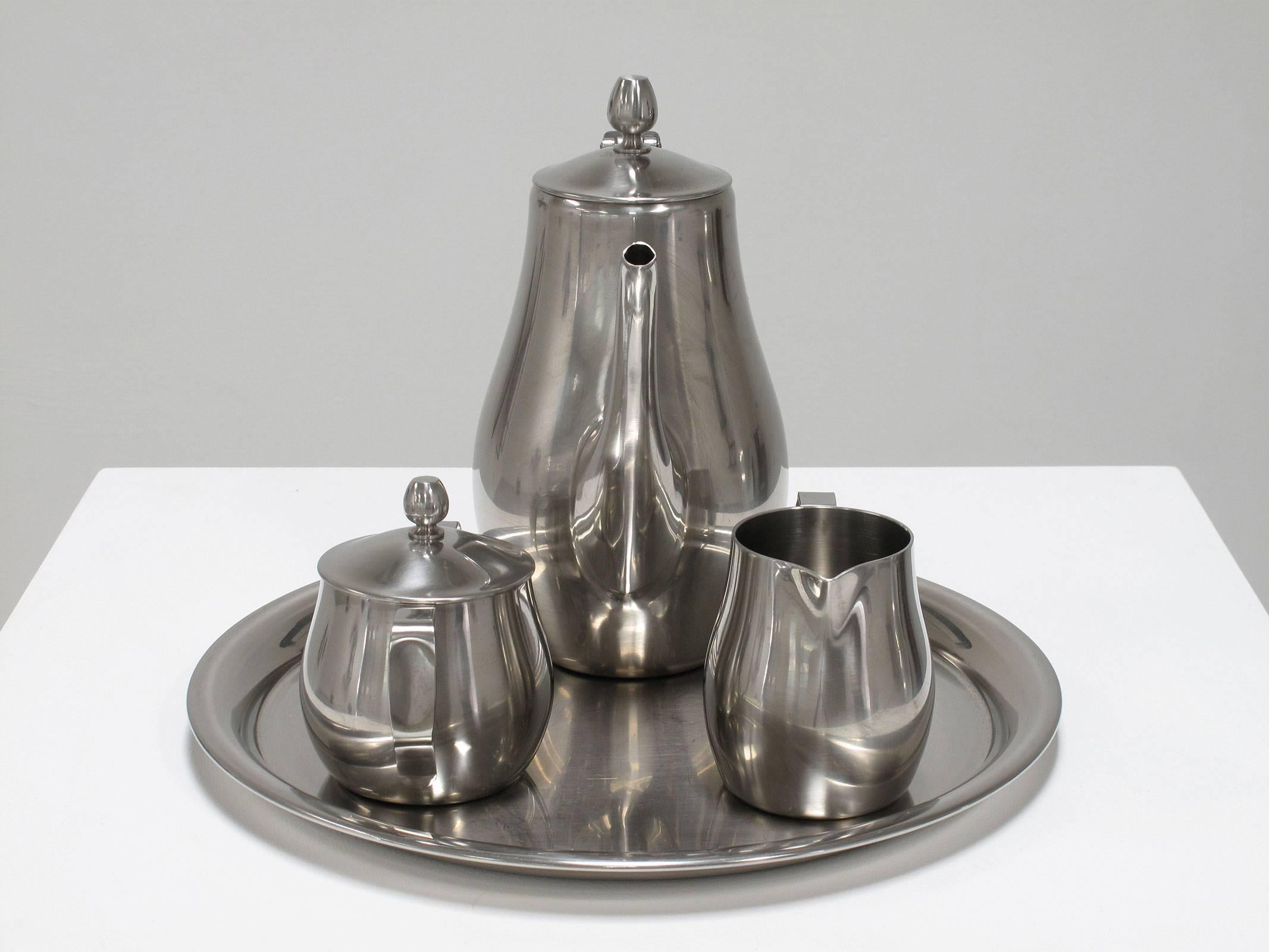 Reed and Barton elegant, deco modern entertaining set including one round serving platter, pot/pourer with a black rubberized cane wrapped handle, creamer container/pourer and sugar/sweetener container with lid
Steel, 18/8 stainless

Each piece in