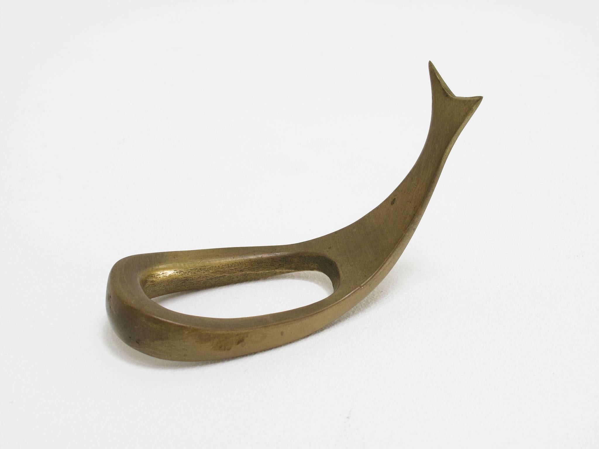 Decorative and functional object in solid brass, cast in an expressive form of a whale with a splashing tail, lightly patinated and rich in texture, attributed to Carl Auböck, 1960s.

Measurements in inches: 2 high x 4 wide x 1.5 deep