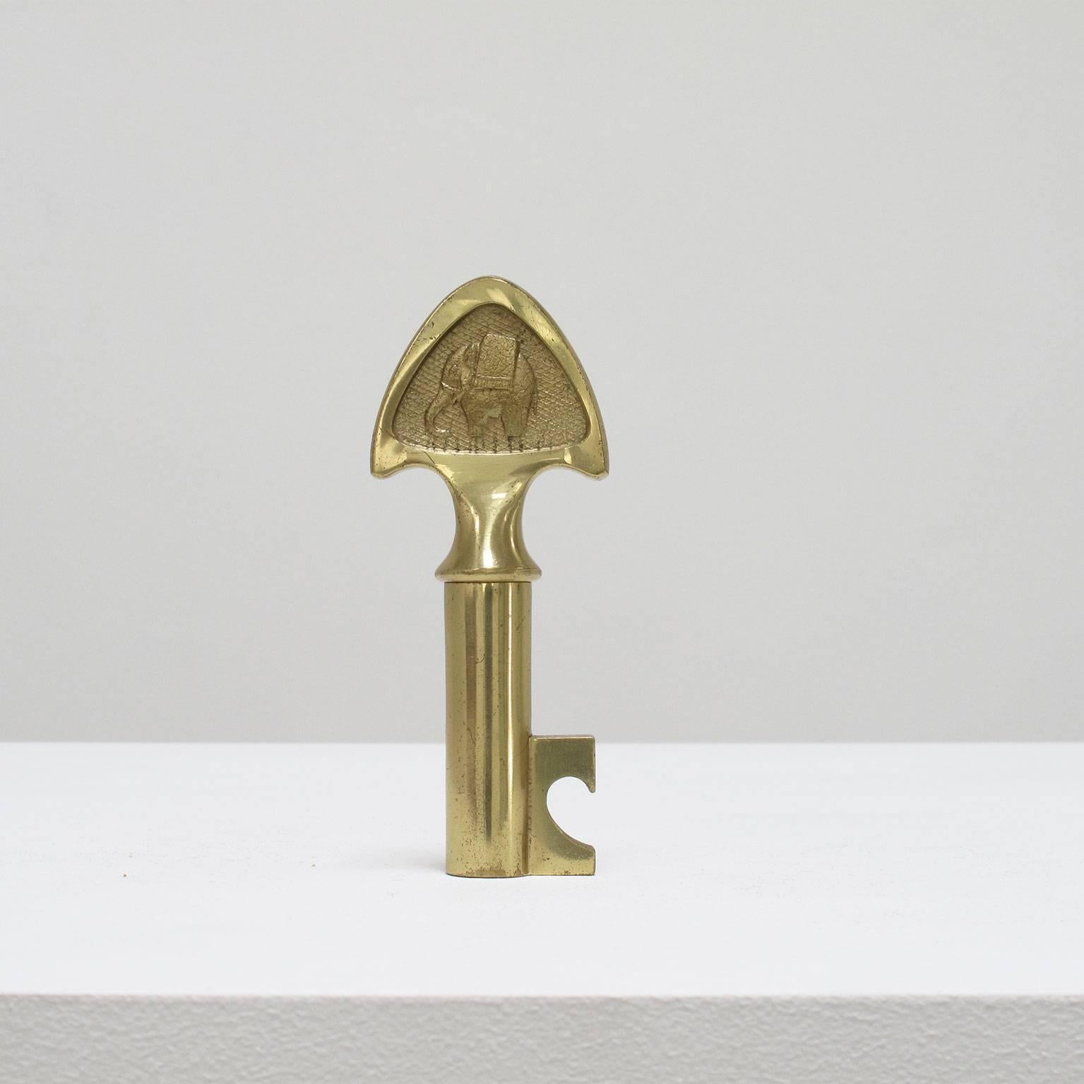 Carl Auböck design object, 1950s, modernist decorative and functional solid brass bar tool with bottle opener and hidden corkscrew, decorated with an elephant on one side, signed, Austria, Werkstätte Auböck, 4 1/2 high x 1 3/4 wide x 5/8 deep
