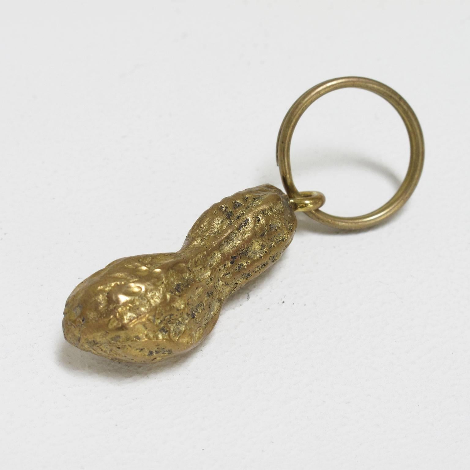 Carl Auböck.
Keyring, decorative and functional solid brass object finely crafted in the form of a peanut, originally designed in 1950 and reproduced in 2000 at the Werkstätte Auböck in Austria

Measurements of peanut in inches: 1 1/2 high x