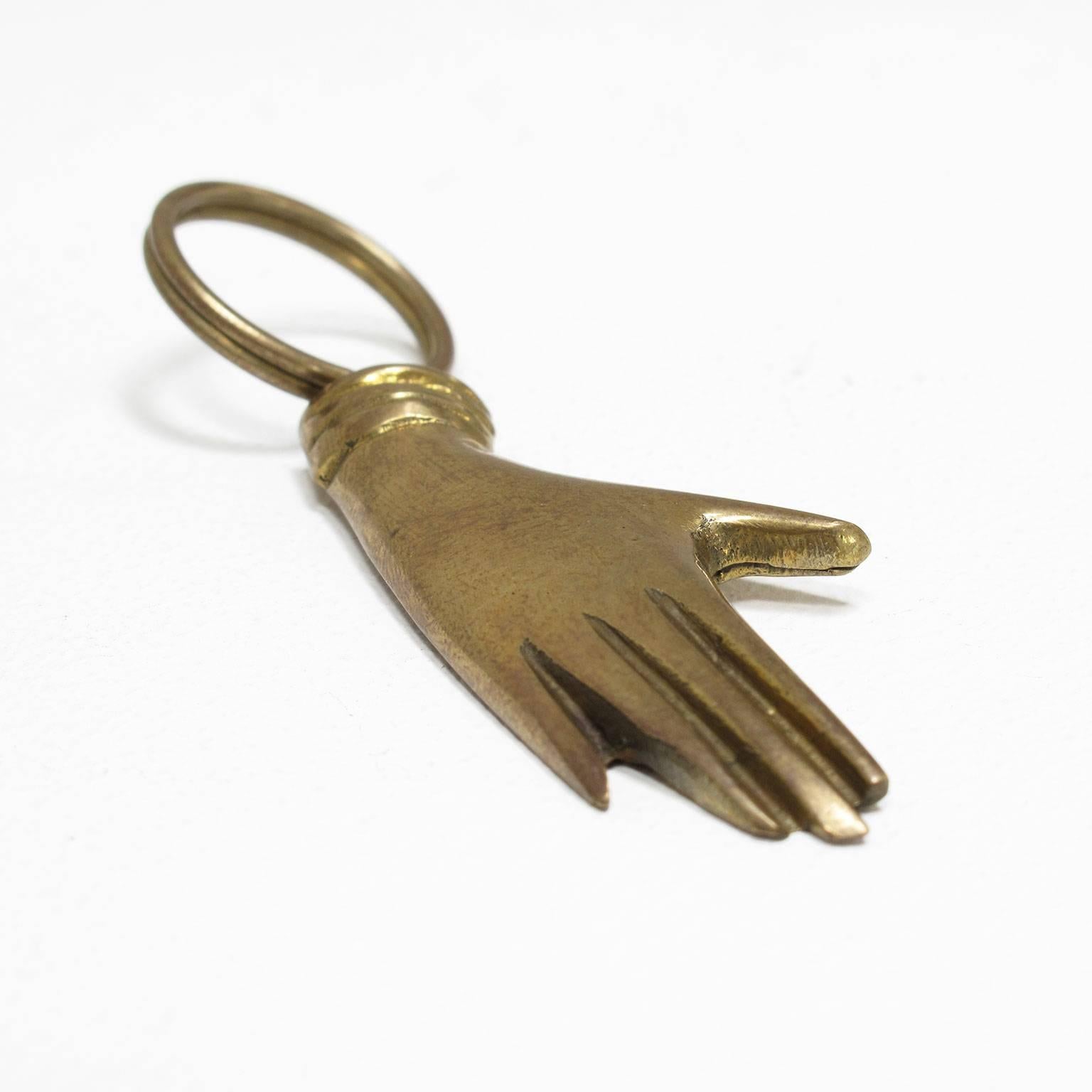 Carl Auböck
Keyring, decorative and functional solid brass object finely crafted in the form of a human hand, originally designed in 1950 and reproduced in 2000 at the Werkstätte Auböck in Austria

Measurements of hand in inches: 1/4 high x 2
