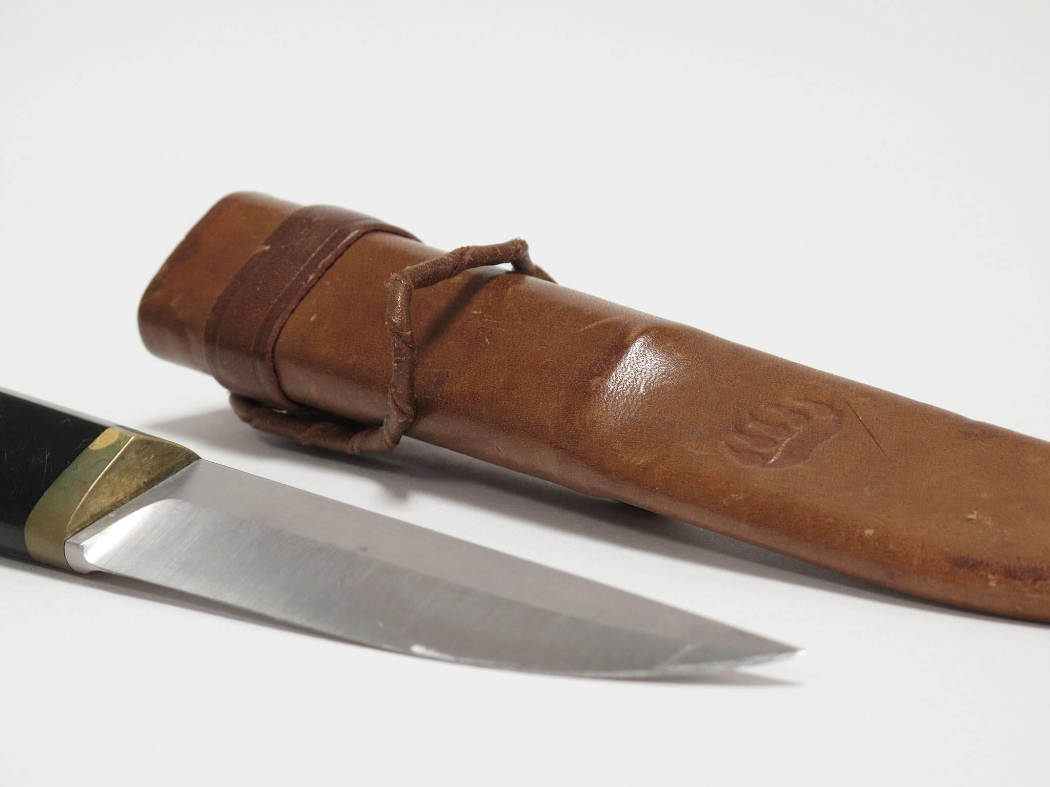 Tapio Wirkkala
'Puukko' knife and leather sheath, 1960s
Hackman Cutlery, Finland
1.25 high x 9 wide x 1.25 deep inches

The blade is made from stainless steel, the bolster and pommel are brass and the handle is black nylon. The leather sheath is