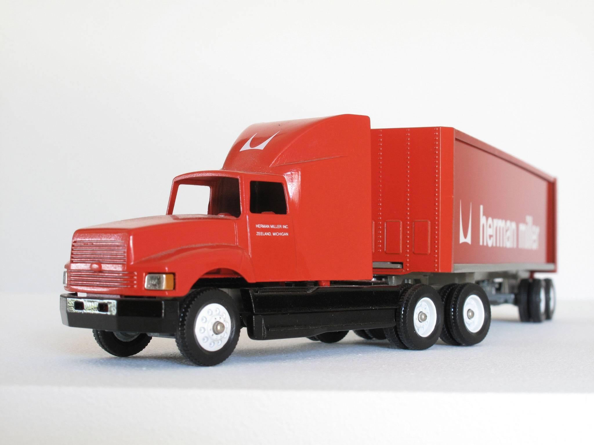Fun, collectible Herman Miller miniature truck advertising, 1:64 scale model, red semi-truck with cab and trailer and white logos, made of die cast metal, paint, plastic.
Dimensions: 2 3/8 high x 10 3/4 wide x 1 1/2 deep inches.
Condition: Good
