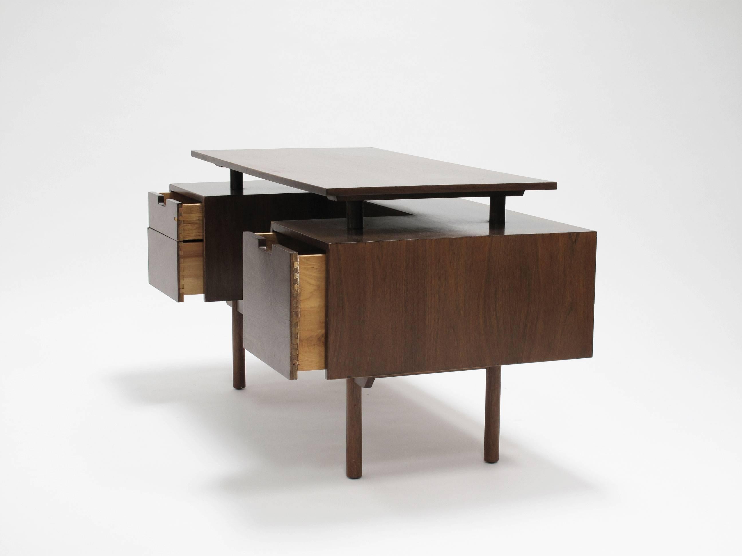 Quintessential California Modern executive desk in walnut veneer with drawers and open front in an architectural case study style, designed by Milo Baughman and made by Glenn of California, 1950s. The floating top measures 24.5 deep by 48.75 wide