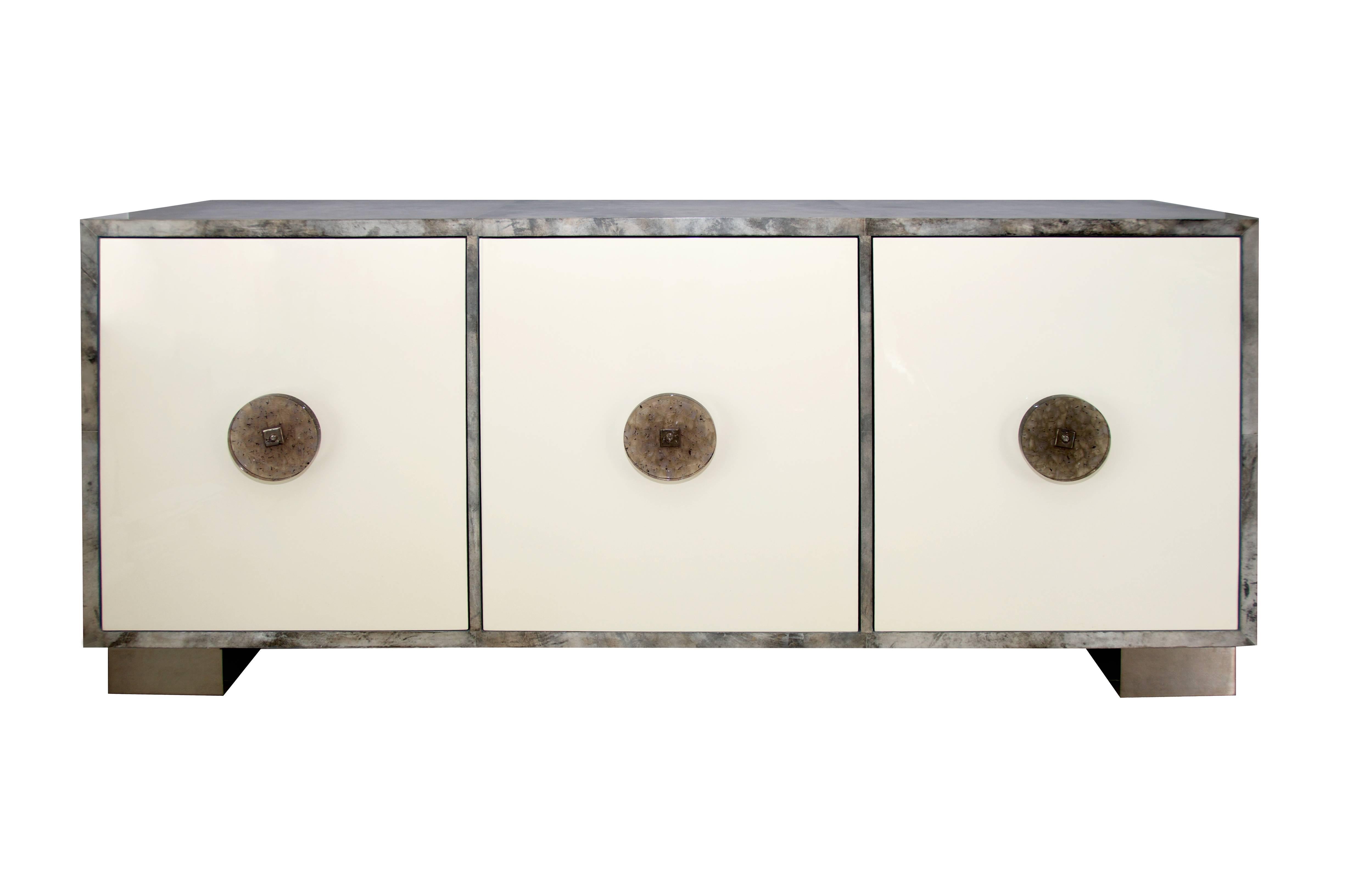 Ultra luxe custom sideboard from the Modern Envy collection by On Madison. Goatskin covered sideboard with lacquer doors, bespoke resin handles on polished stainless steel legs. Custom sizes and colors available. 11-12 week production time.
