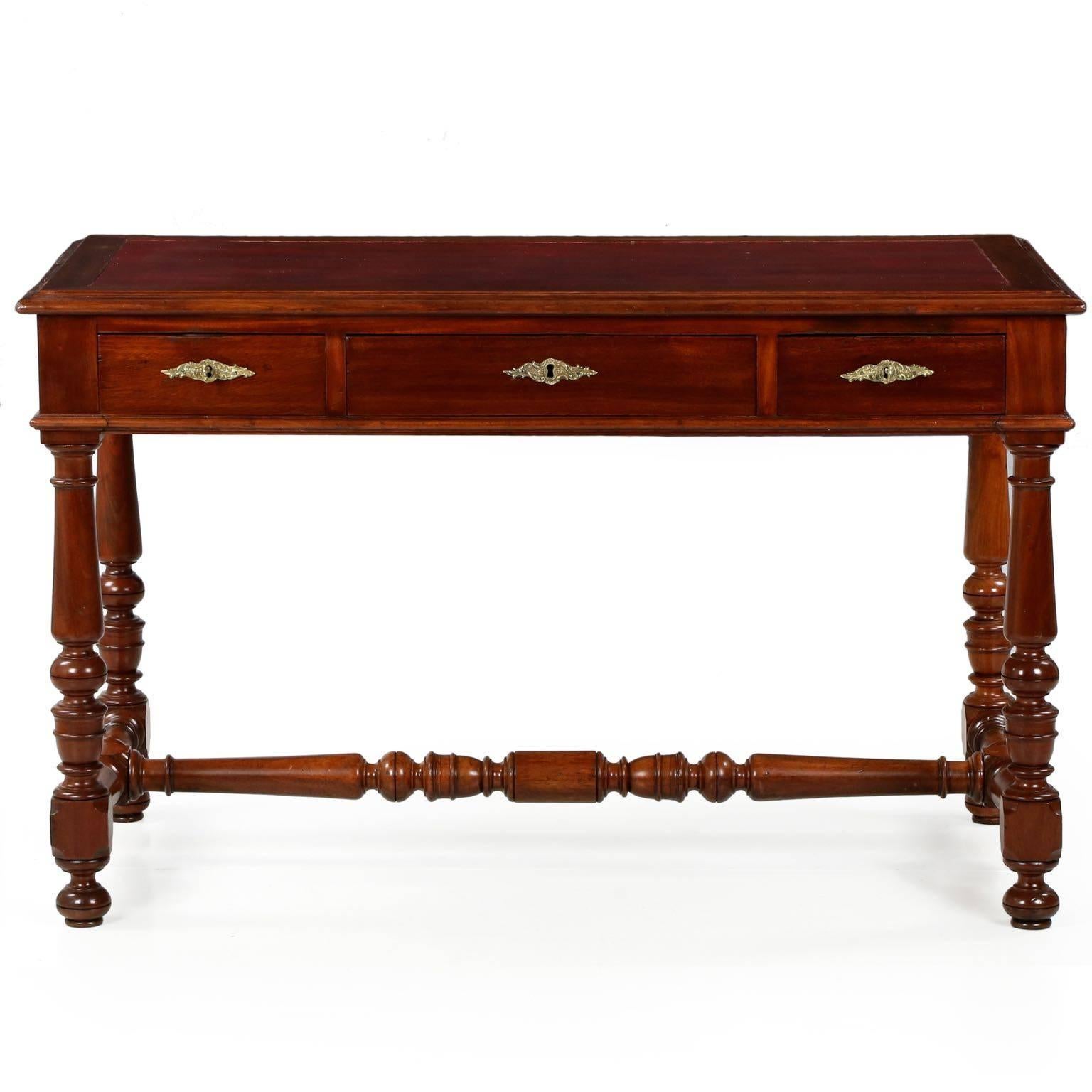 A very well crafted writing desk from the turn of the century, this is almost certainly an English piece, the craftsmanship tight and precise throughout. The simple molded top frames a relatively fresh untooled red leather writing surface,