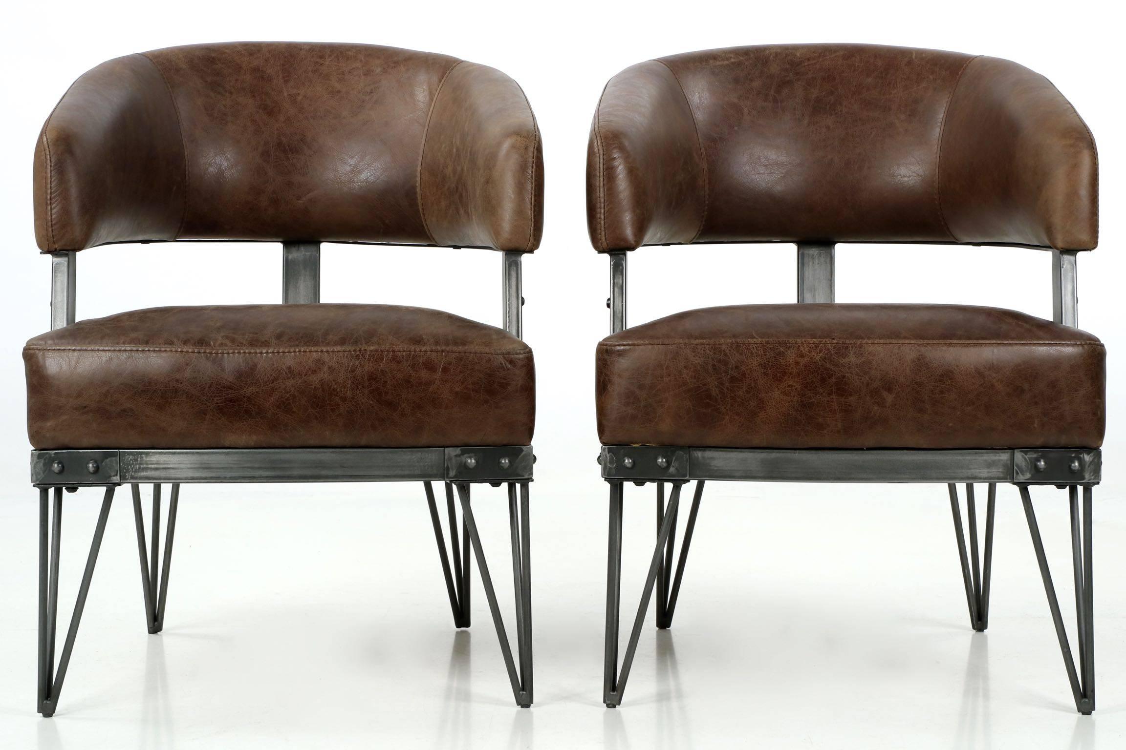A heavy and well-crafted pair of French Industrial style arm chairs, these are probably crafted in the last decade and remain in nearly impeccable condition. The high quality stitching in the leather joins the upholstery with near perfection, the