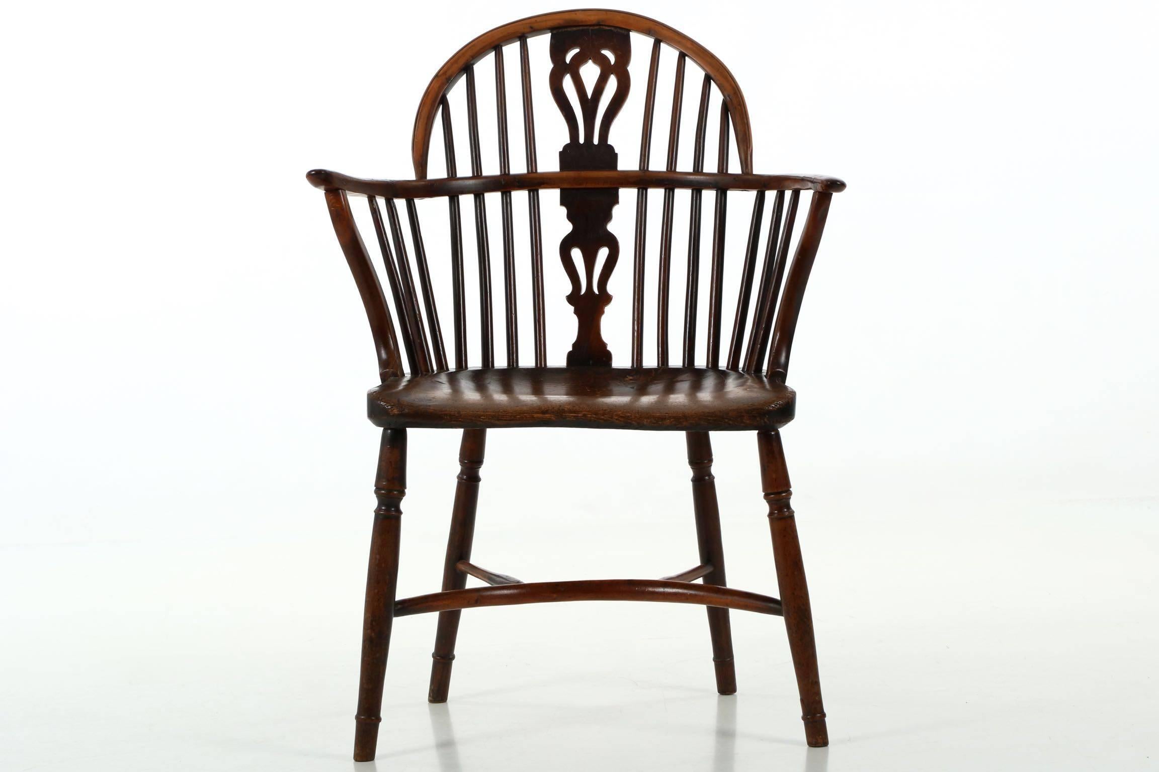 This very fine early 19th century Windsor armchair, a form generally produced during 1810-1840 with a pierced splat design closely related to signed chairs in Worksop and Nottingham in England. In our experience, yew wood worn over time produces one