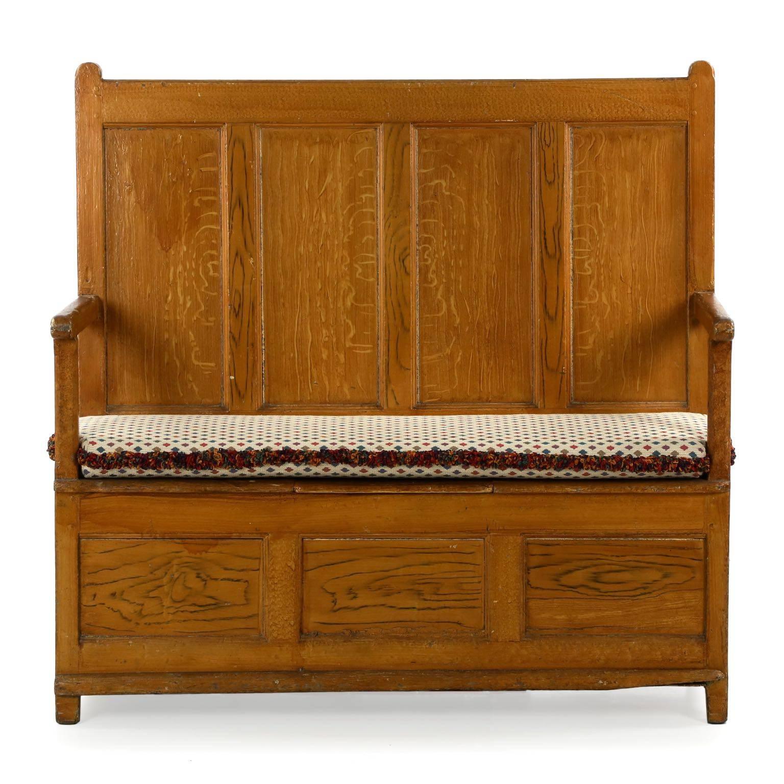 An orderly and precisely built piece, this bench was generally intended in the entryway or hallway of a country home, allowing one to rest to put on or remove shoes before proceeding. The cushion covers a lid that opens to provide access to a large