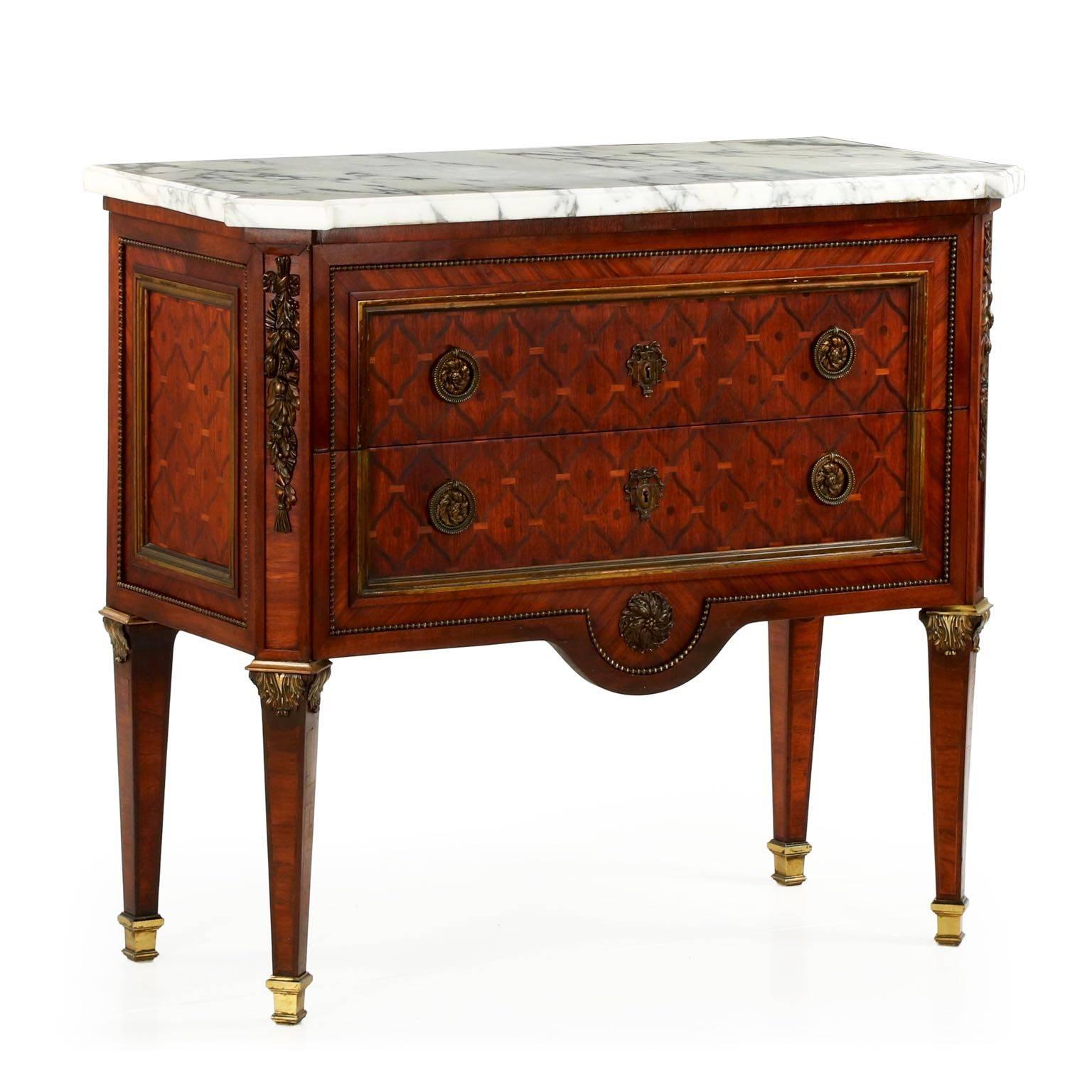 Of a most fine quality, this commode was crafted during the last quarter of the 19th century during the Bell Epoqué. Distinctly square and severe in angles, the commode is a statement of geometry and competing lines. A repeating squared parquetry