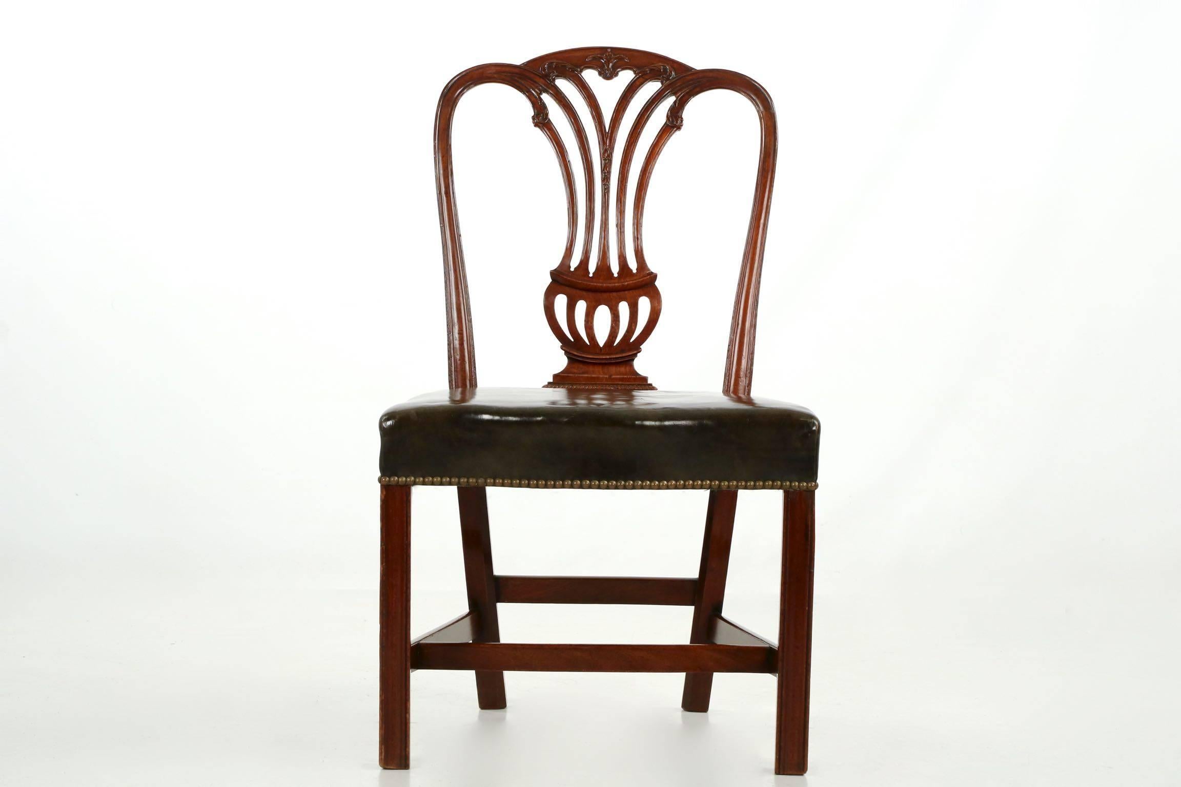 Of masculine form and proportions, this fine Georgian period side chair features a fully developed vasiform splat with intricate displays of carved foliage sprouting from the tips of the pierced splat ventricles, these rising in a dramatic outward
