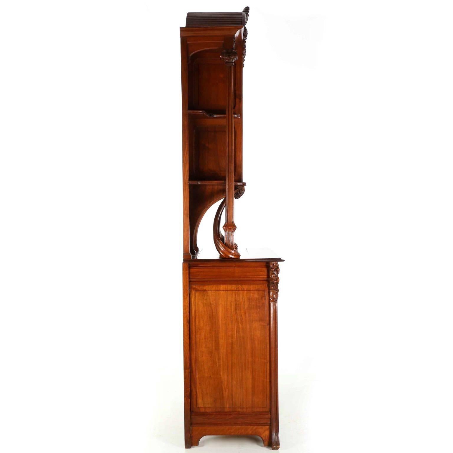 An incredible presentation work that captures the very essence of the naturalism of the period, this highly organic cabinet is crafted of gorgeous solid walnut primary woods carved ingeniously to incorporate the flowing roots and generous foliage,