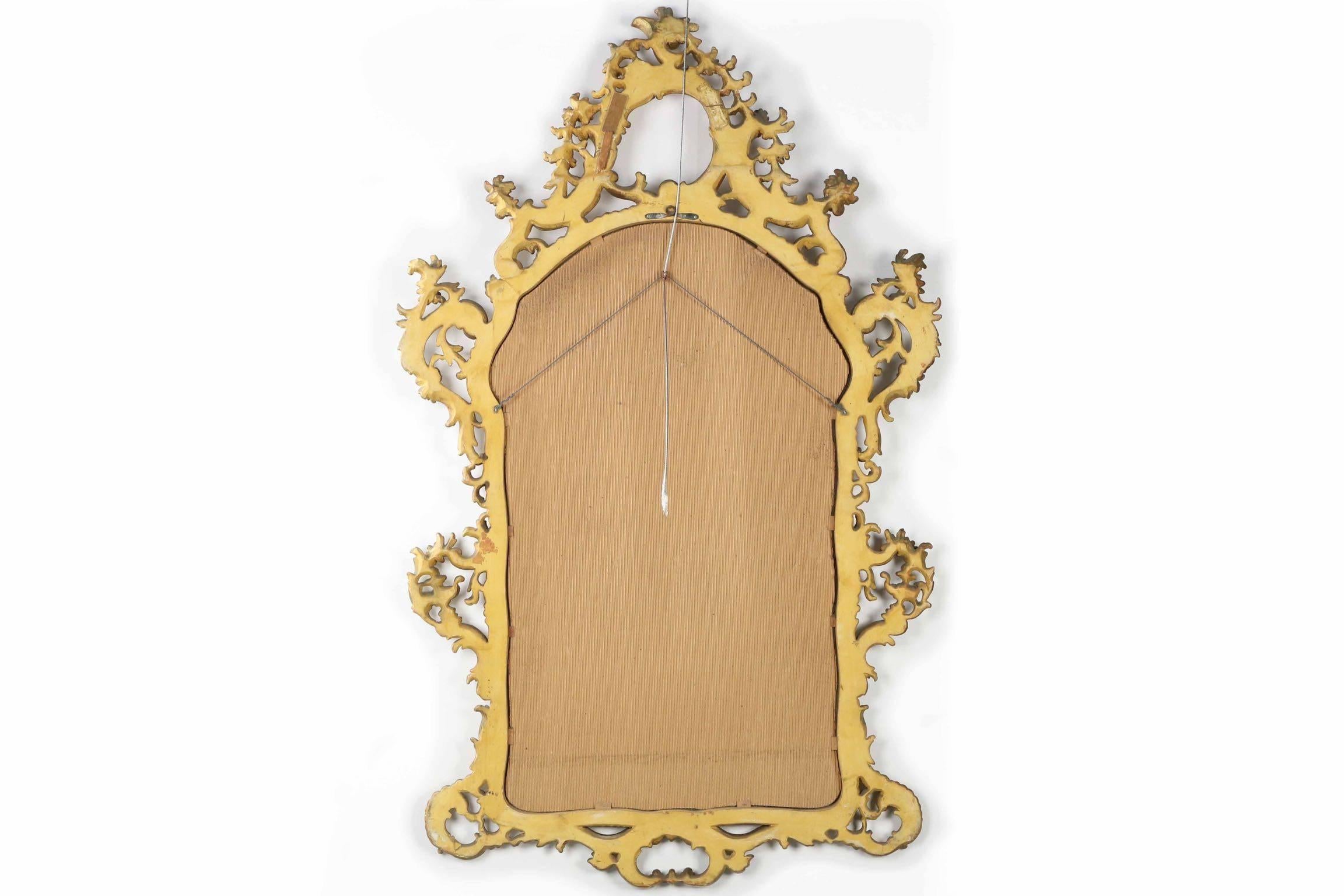 A profusely carved and very finely detailed mirror executed faithfully in the Louis XV taste, the gorgeous handwork was finished with a red bole and then gilded. Probably crafted during the first quarter of the 20th century, the surface has