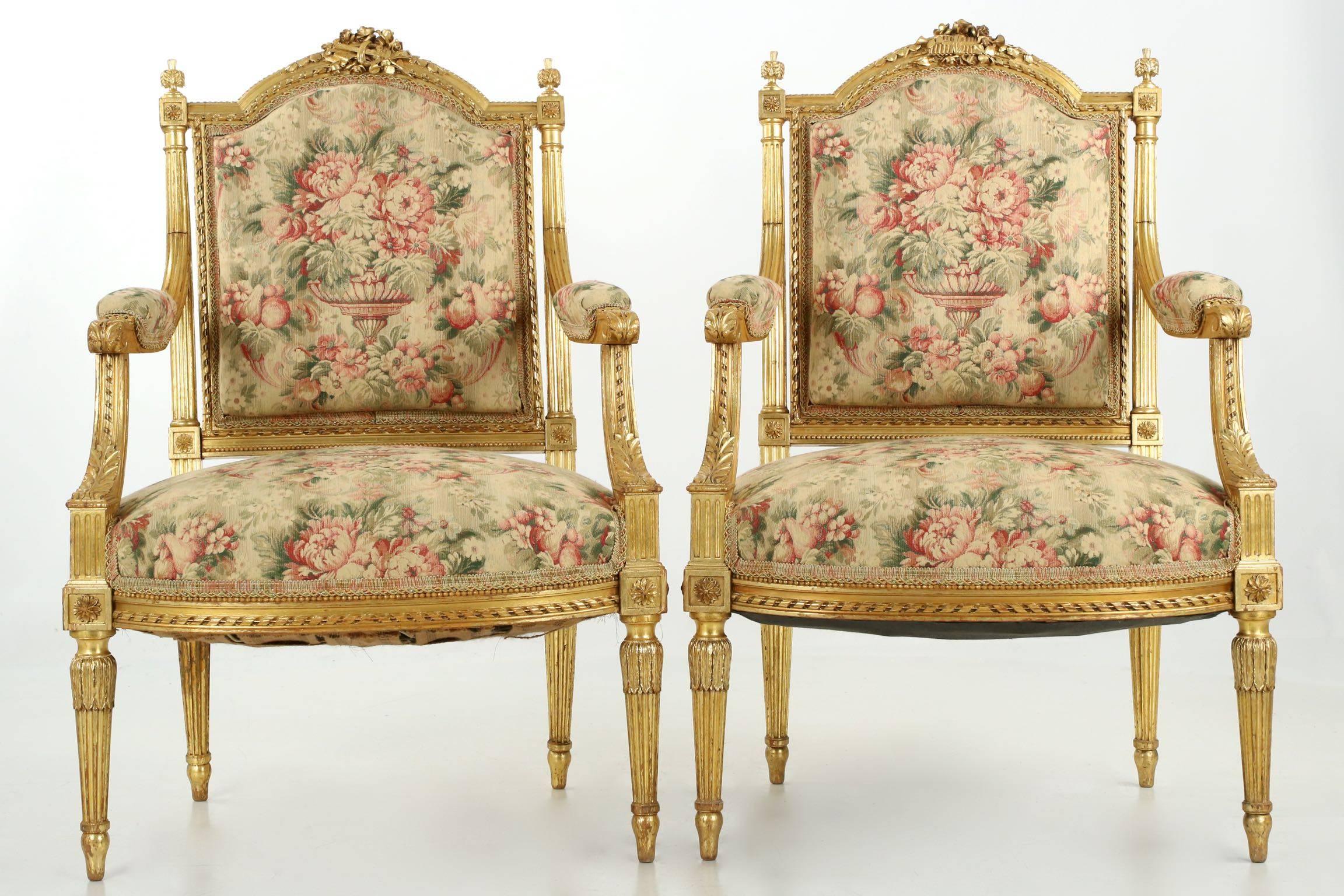 Introducing a dramatic pair of Louis XVI fauteuils, detail rich with extensive, exquisite hand carving and gilding. At the chair apex is a carving of a “bouquet” of various musical instruments: harps, sheet music, horns, flutes; with a setting of