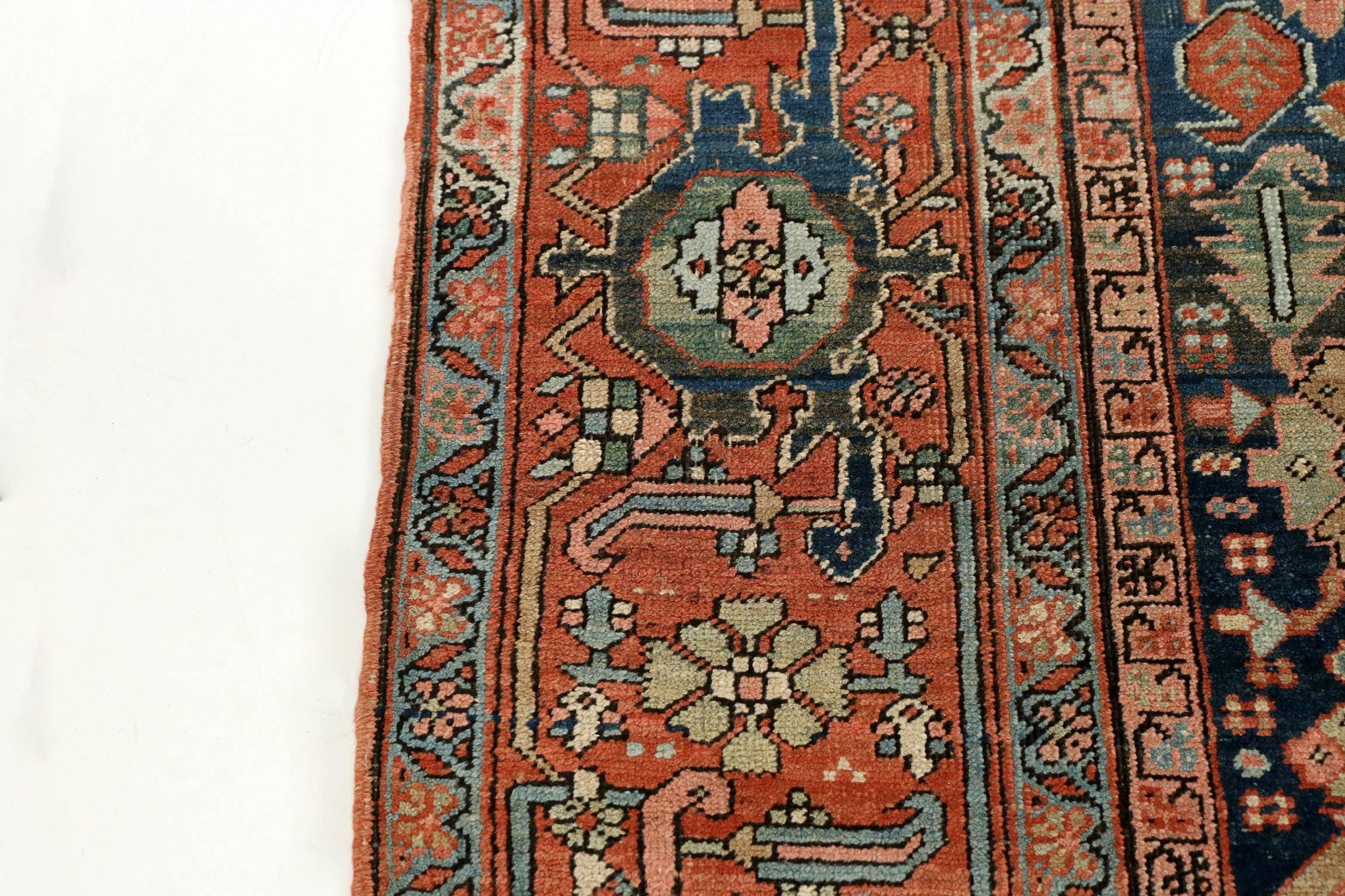 A noteworthy carpet for its fine mellowed colors and outstanding condition, this gorgeous Heriz rug is wonderfully complex with an intricate display of foliate across the navy ground of the primary. There is a vein of activity that stretches from