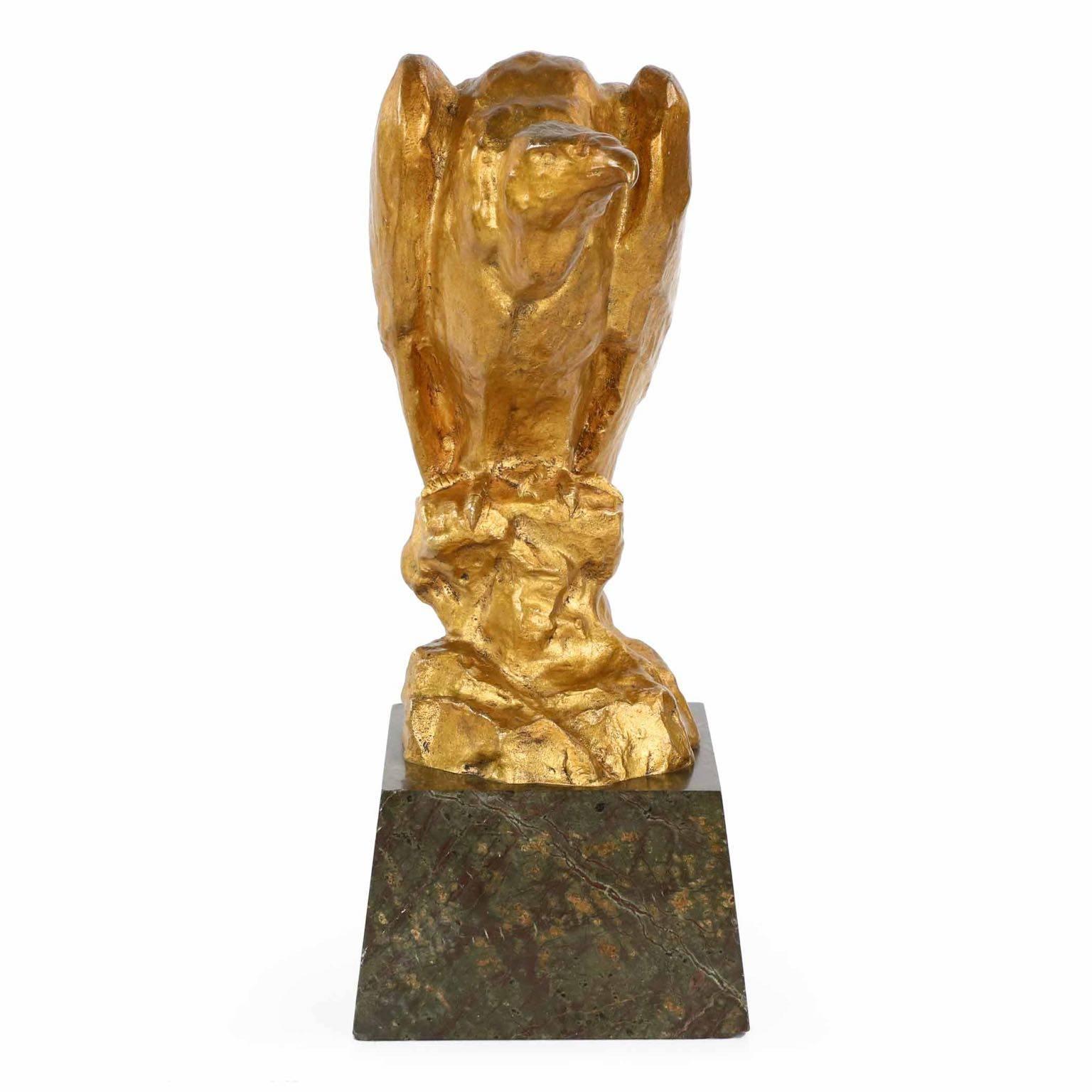 This rare and Fine gilded bronze sculpture of a prone Vulture is a striking work of impressionism, loosely capturing the essence of the bird with mottled features against a brilliant golden patinated surface. The high burnish of wax against smooth