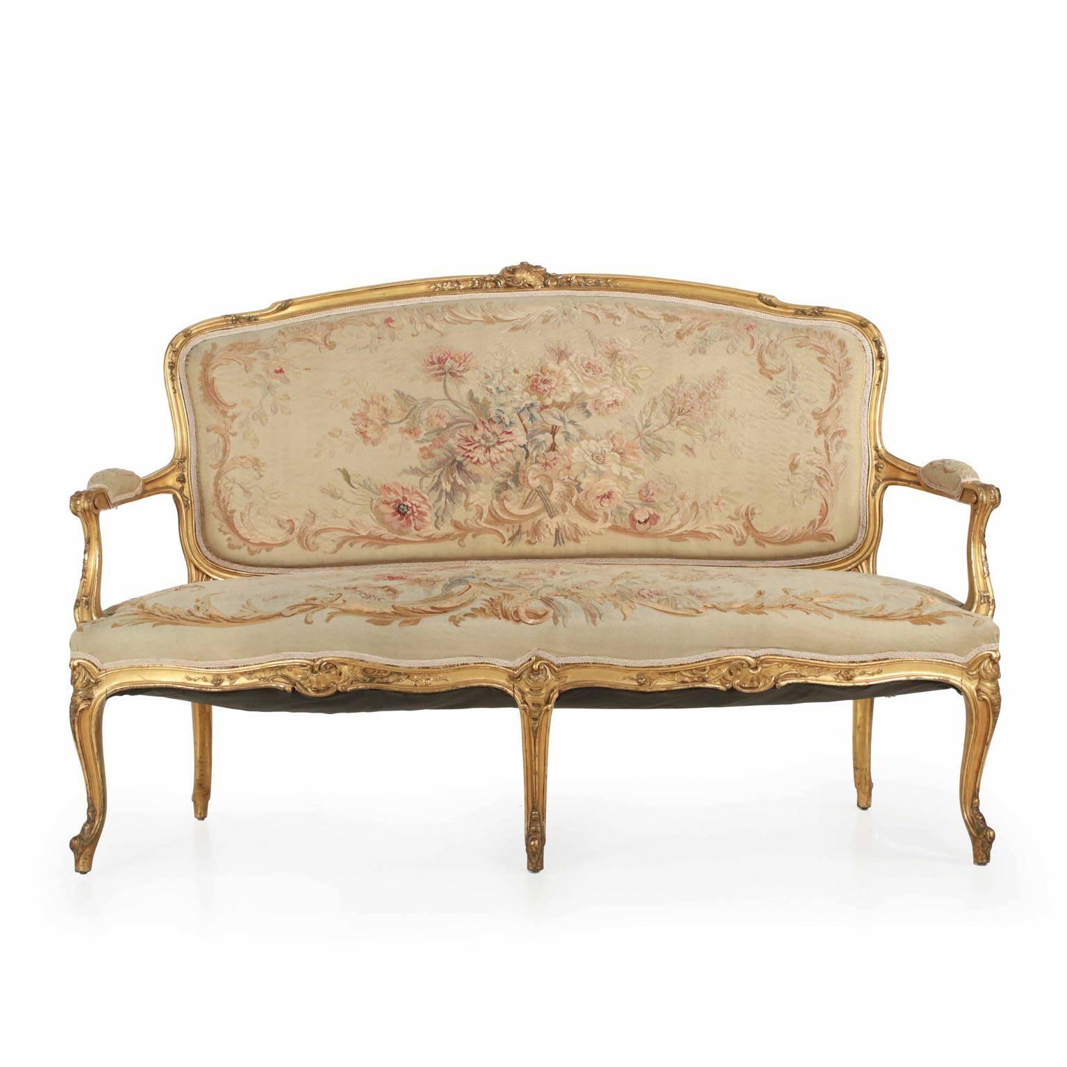 A most fine settee in the Louis XV taste from the turn of the century, this is a statement of rich form and material. Sumptuous curves are highlighted with the most crisp of carvings, these lively Rococo motifs centering around the Rocaille with