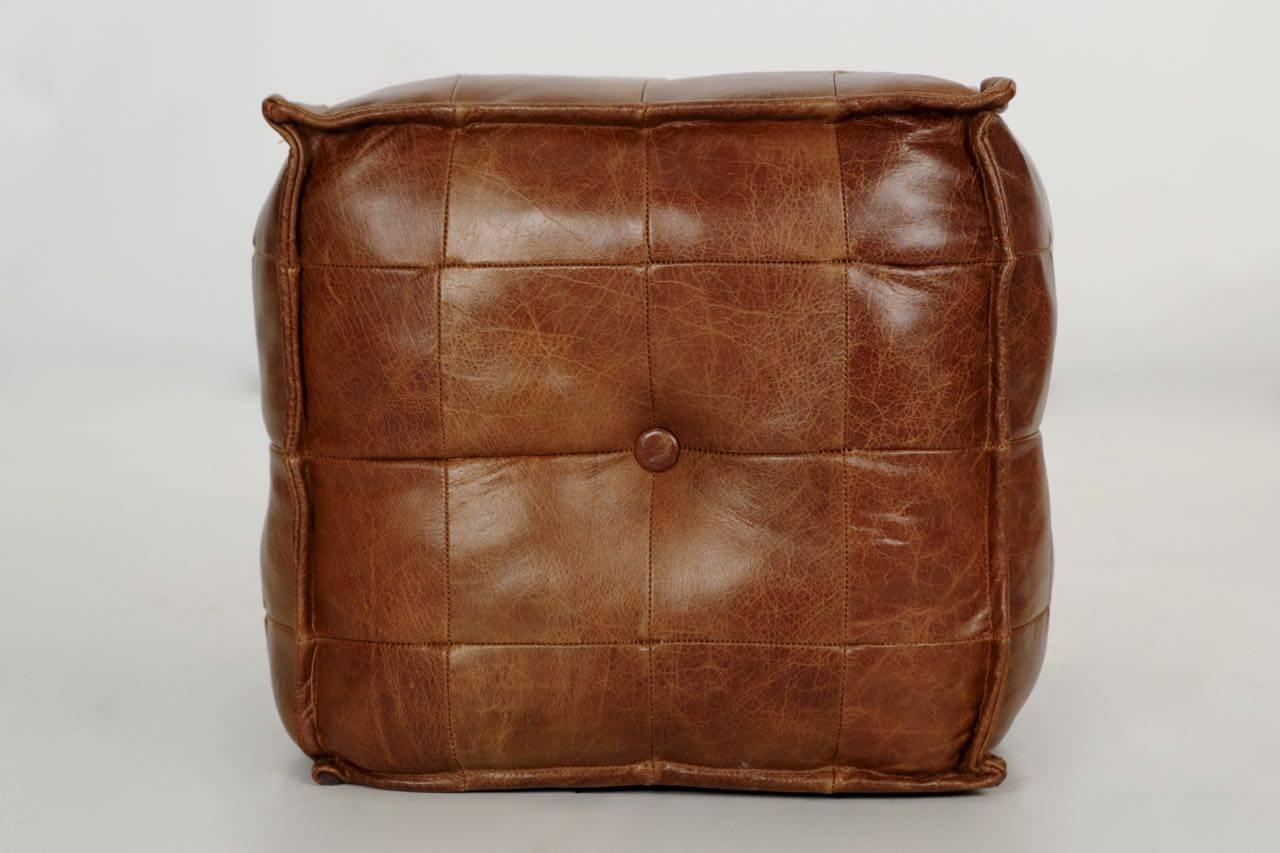 Crafted with a beautiful thick stitched leather pouf with sixteen patches to each side and a single tufted button centrally, this is a most comfortable little accent. The warm leather retains a beautiful patina from light wear over the years while