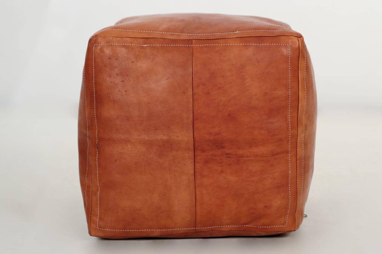 This is a gorgeous and most comfortable little accent, crafted out of thick and luxuriously soft brown saddle leather with a deeply stuffed interior. The warm leather retains a beautiful patina from light wear over the years while remaining in