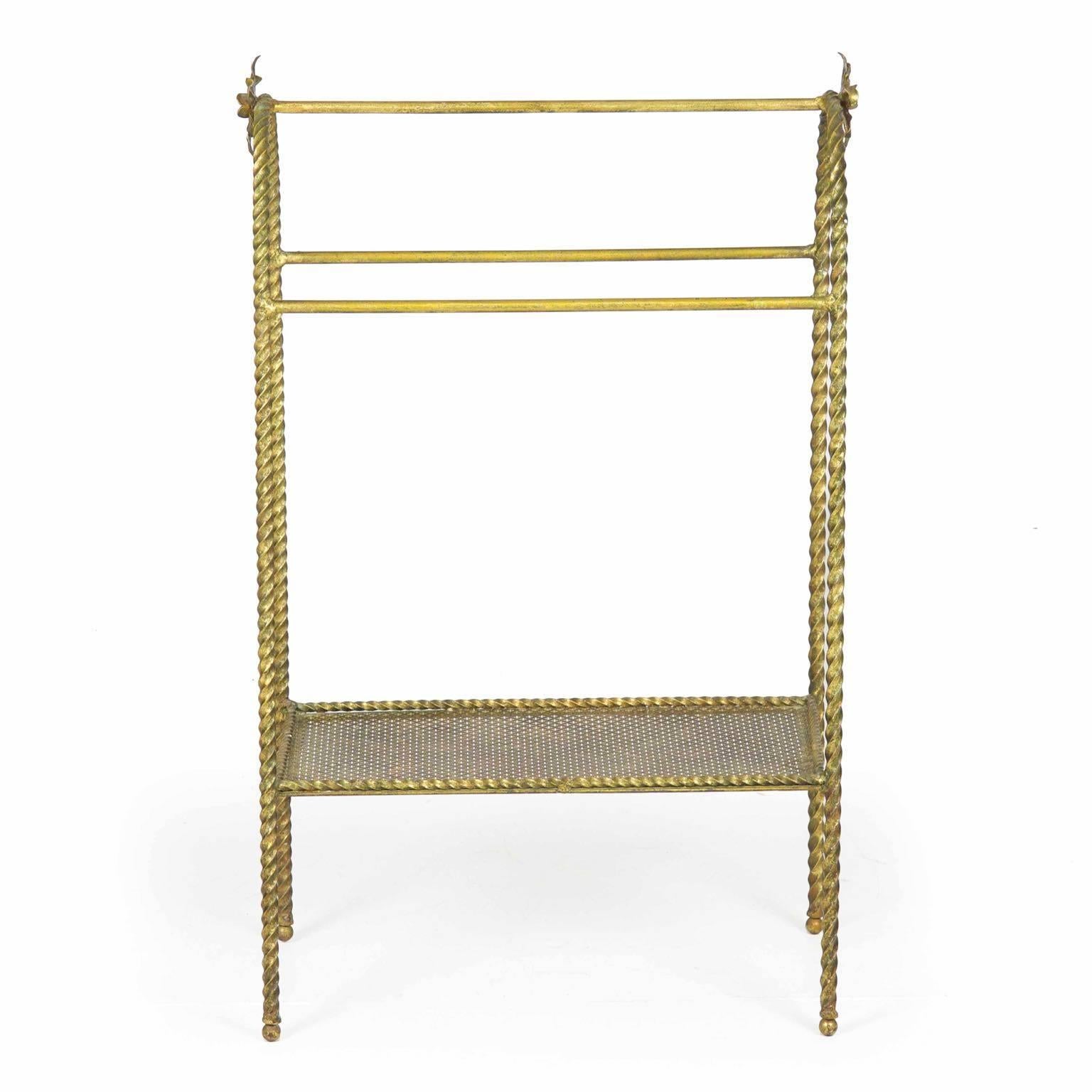 A very attractive and high quality towel and magazine rack from the middle of the 20th century, this piece is crafted of solid cast bronze that is finished in a complex gilding.  On either end of the rack are large open flowers flanking the