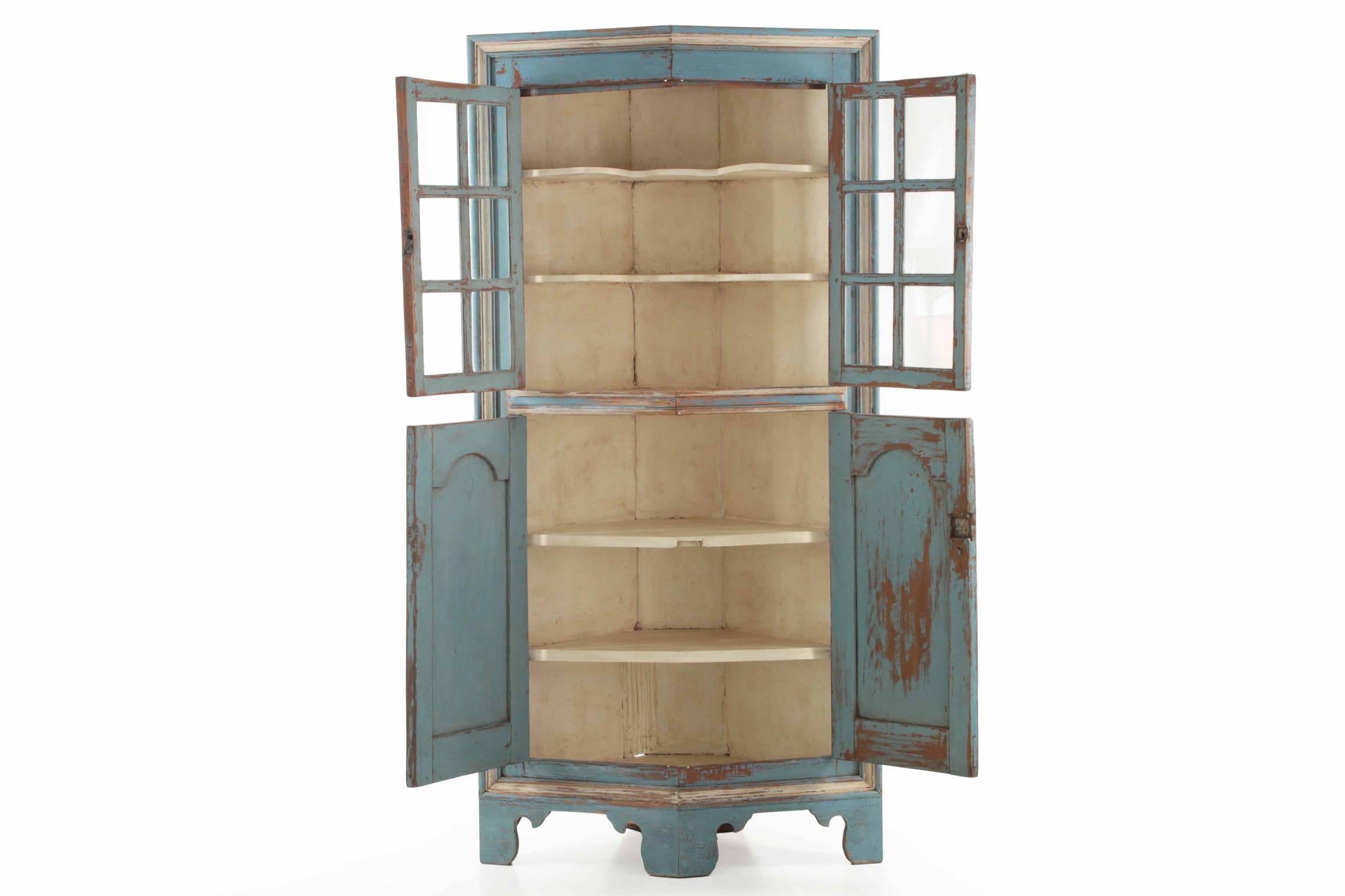 This carefully crafted cabinet is a visually stunning, deeply patinated and worn work with great form and sense of age.  The faceted shape is just gorgeous - a pair of doors with six glass panes under worn molded astragals framed in double-pinned