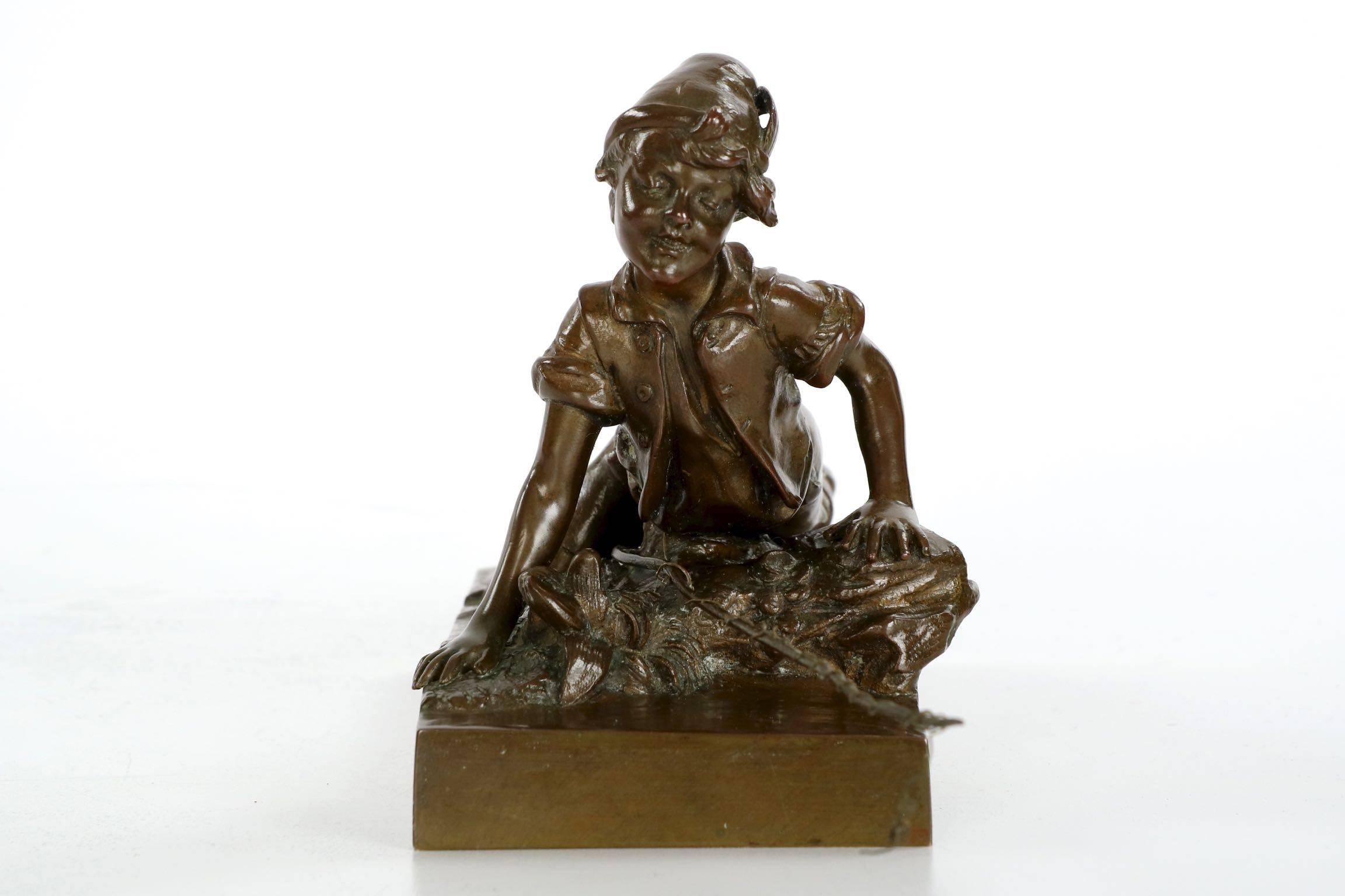 This fine Austrian antique bronze sculpture captures a young boy as he delightfully looks over the waters edge for fish. His home-fashioned fishing pole, a long branch with twine wrapped around the length, rests beneath him to be easily accessed