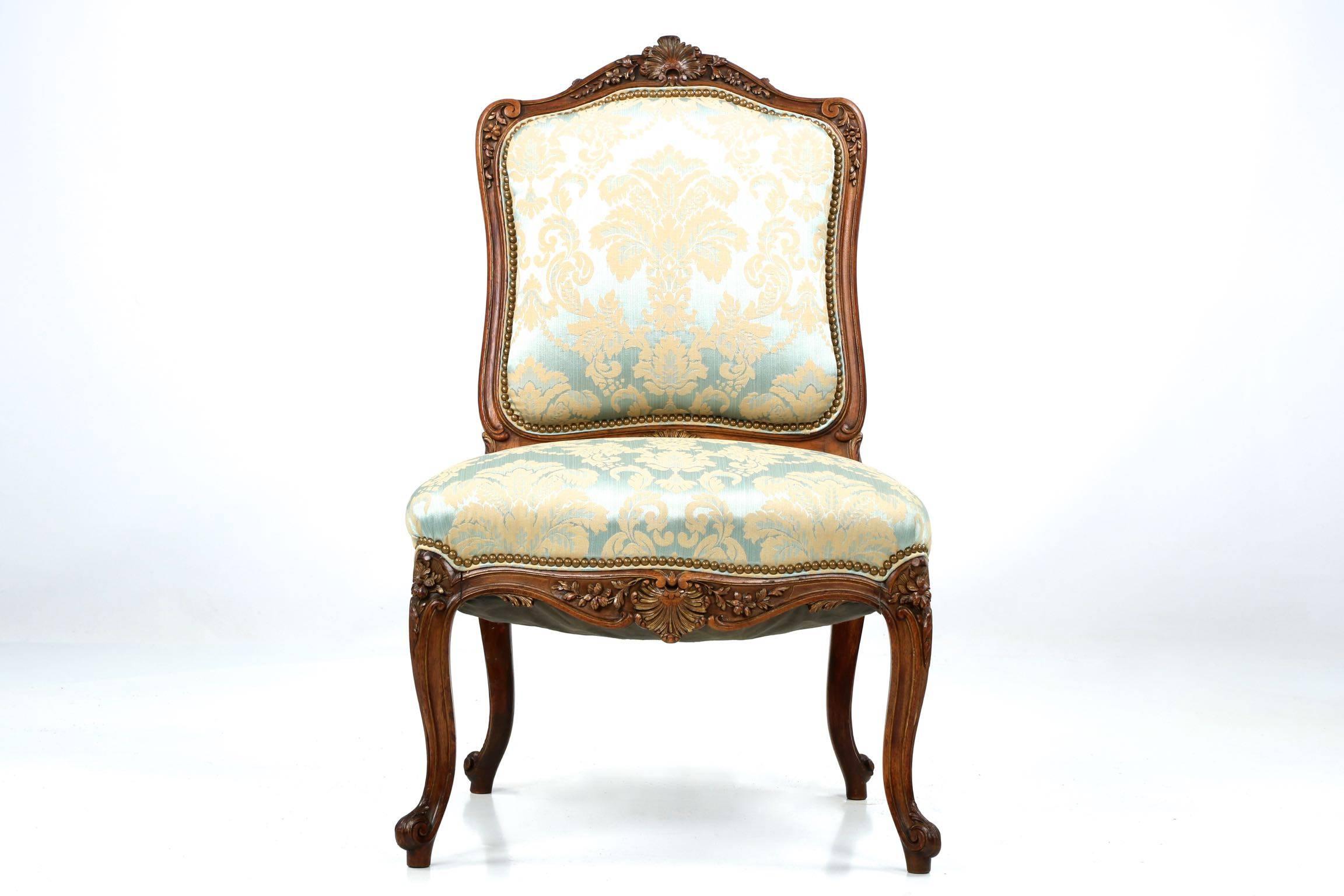 Exquisitely carved and crafted during the Rococo Revival period, a reinterpretation of the original Louis XV designs of 100 years prior with what, at the time, was a modern twist. The crest rail is an intricate display of rocaille and floral motifs,