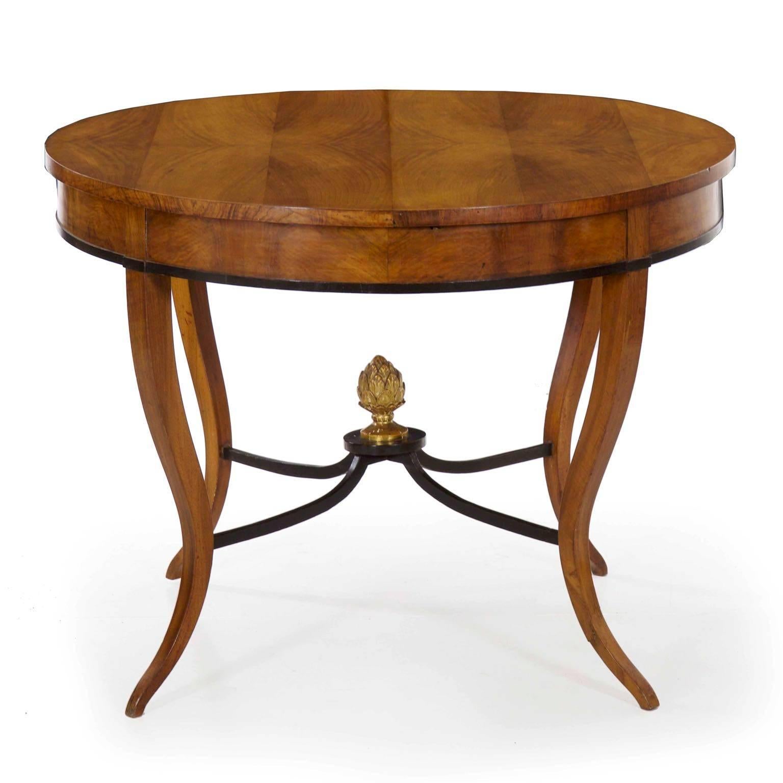 A very elegant form with a lightness of profile that is most admirable, this fine center table exhibits a skilled matching of veneers throughout. The top is arranged in six bookmatched bands of alternating hues of fruitwood, allowing for a stunning
