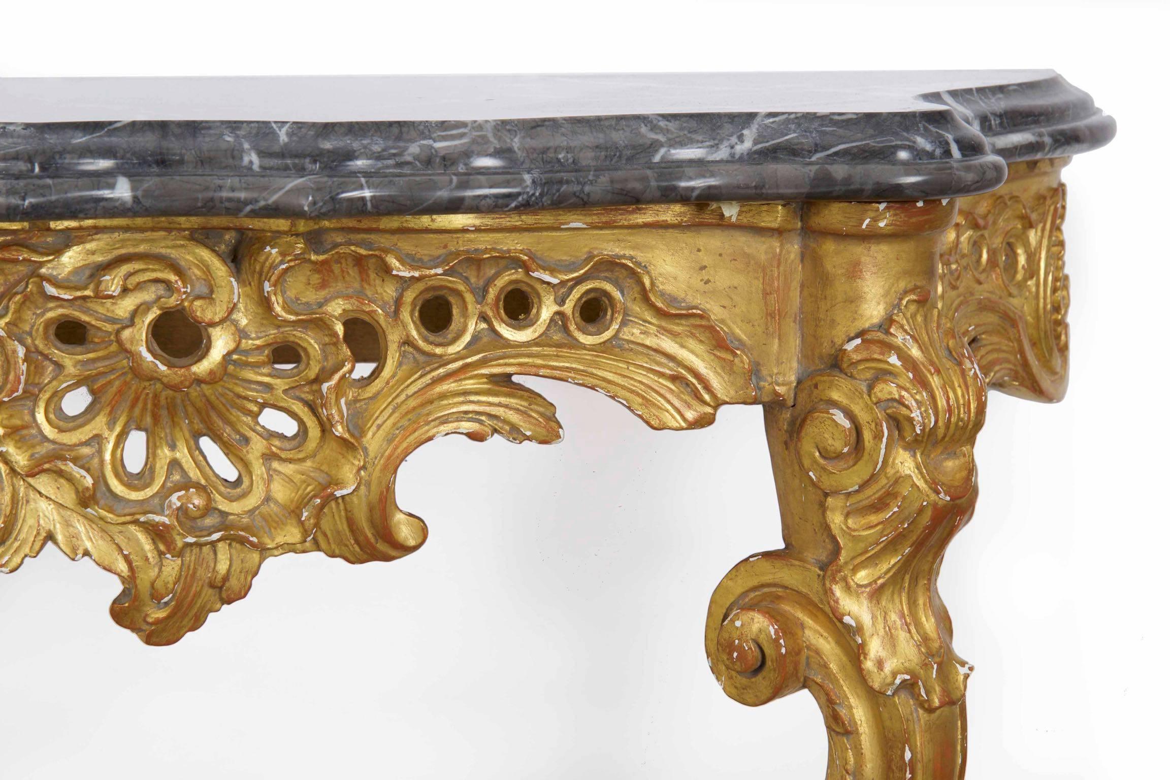 Diese wunderschön geschnitzte Konsole aus vergoldetem Holz im Louis XV-Stil wurde wahrscheinlich in der zweiten Hälfte des 20. Jahrhunderts angefertigt. Die Marmorplatte ist sehr attraktiv und passt sich der Wölbung des Rahmens an, wobei der Rand