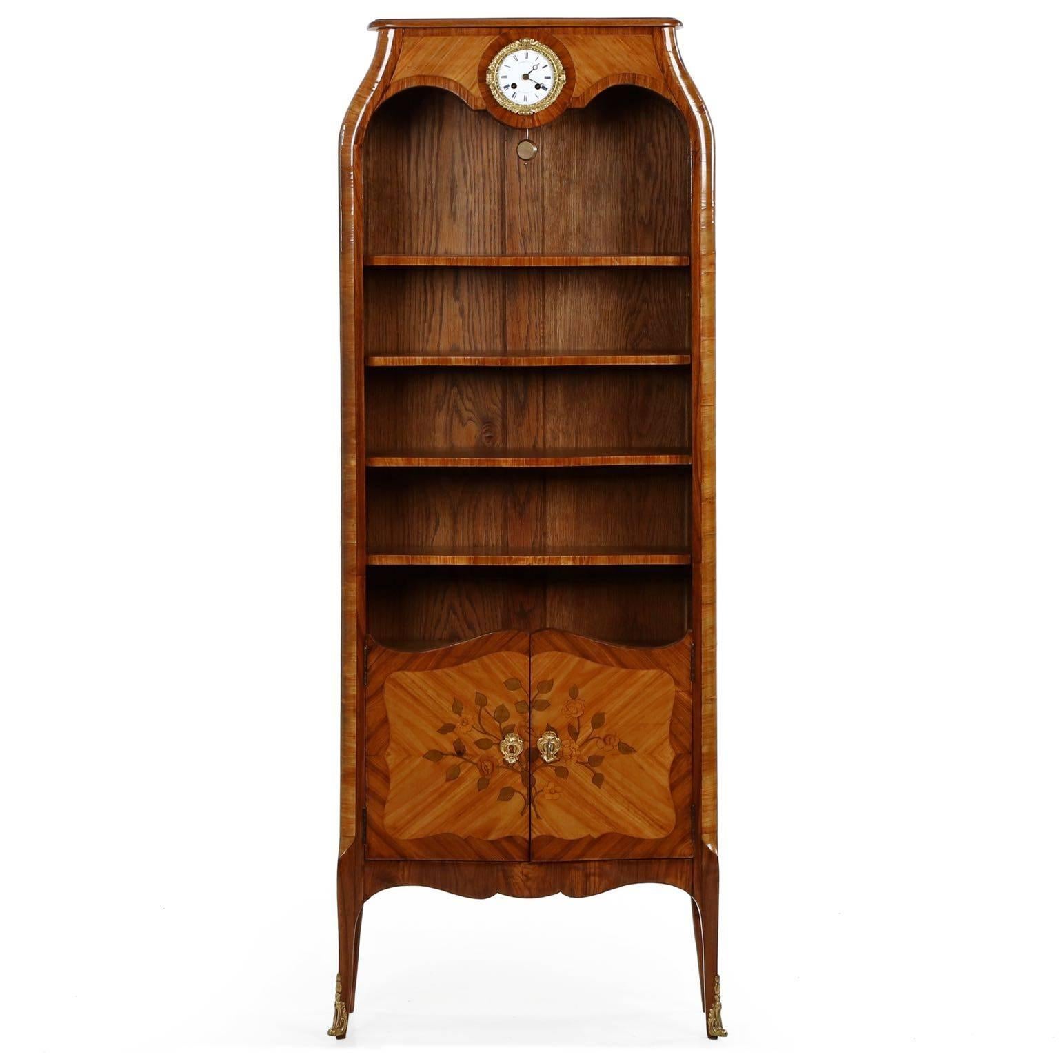 An intricately veneered case with a lovely form and dimension, this very fine bookcase is crafted in the Louis XV taste during the height of the Belle Epoque period at the turn of the century. With only 7 1/2” in overall depth, the case barely
