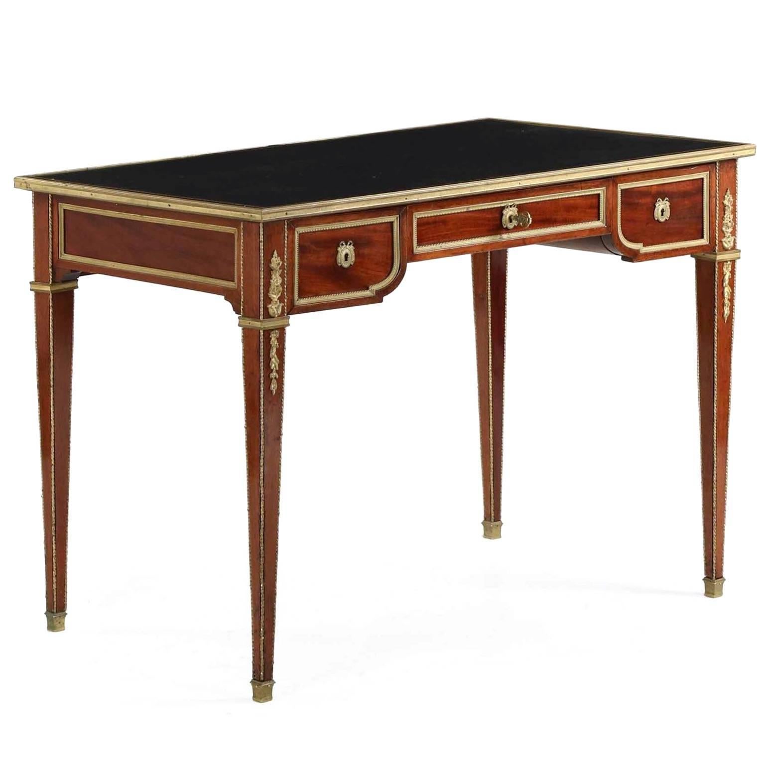 A refined and elegant writing table crafted during France’s opulent Belle Époque period, this crisp and angular little neoclassical bureau plat exhibits the best of the period. Vibrant ruby mahogany woods are used throughout all primary surfaces