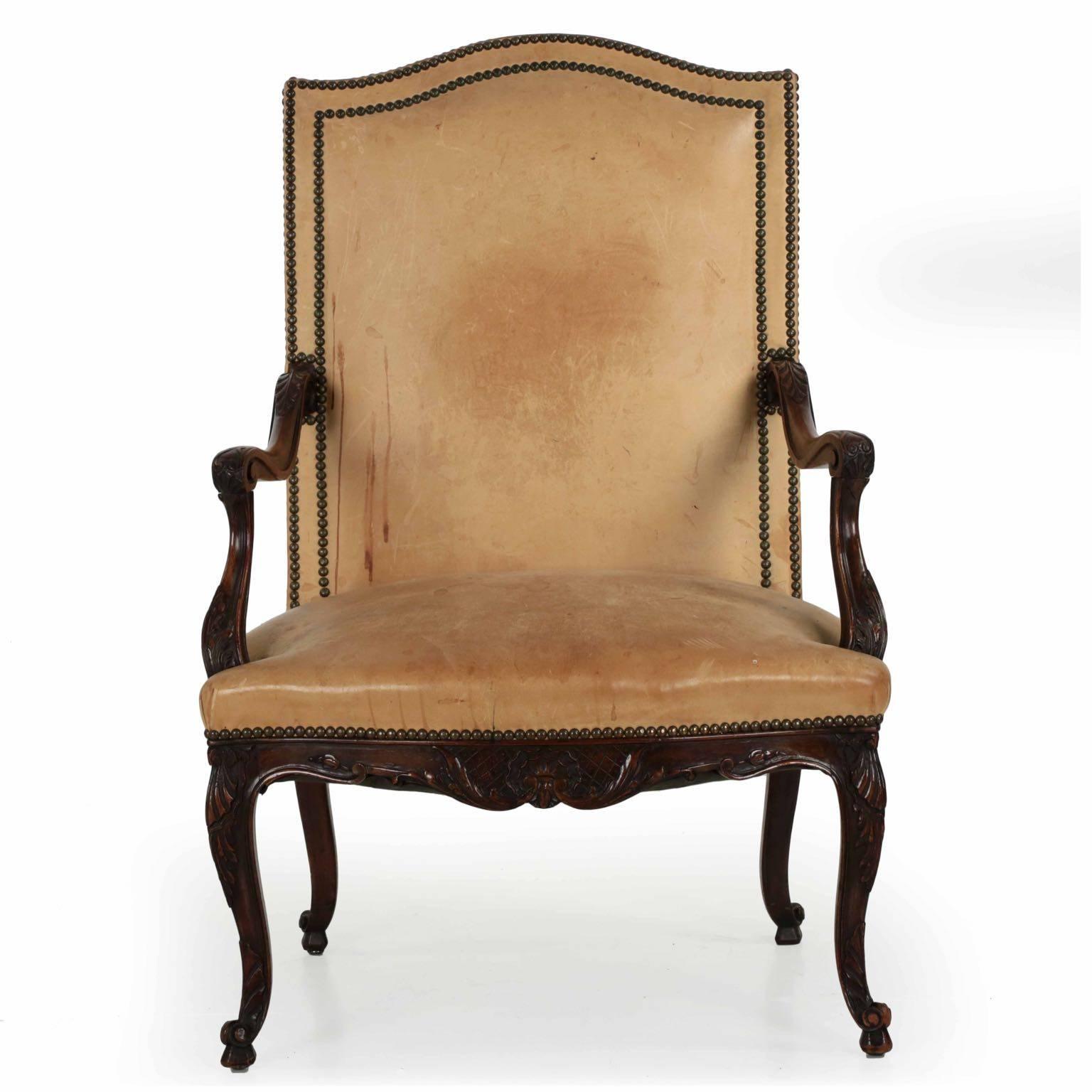 A gorgeous armchair with an early and beautifully patinated latte leather covering, it was crafted during the last quarter of the 19th century, probably in France. The crispness of the carvings is nicely preserved in the dense mahogany woods