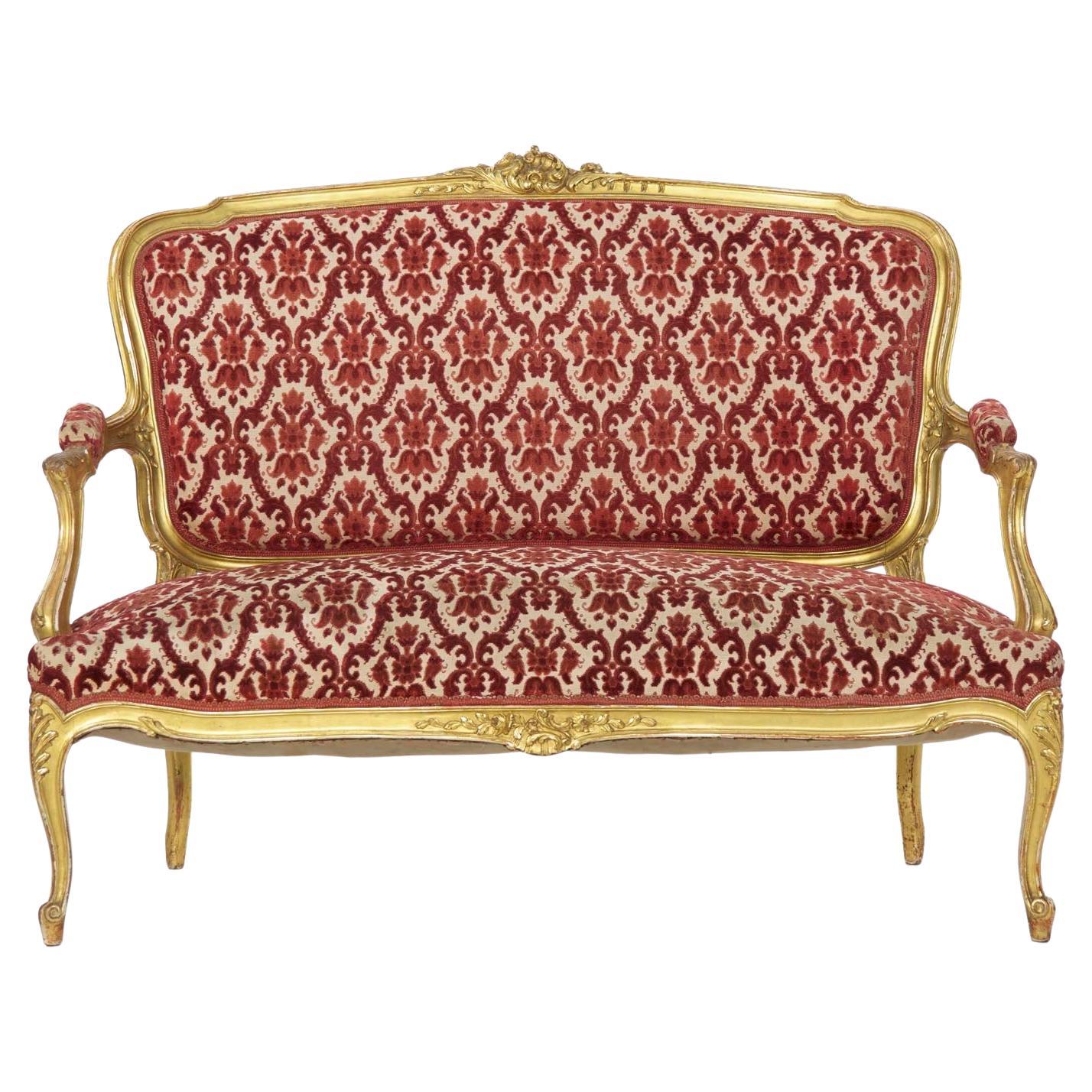 A gorgeous and sleek settee of fine quality with crisp carvings and an excellent profile, this is an excellent strike point piece for the salon or living rooms. Each grouping of carved motifs is centred around the naturalism of acanthus and foliage,