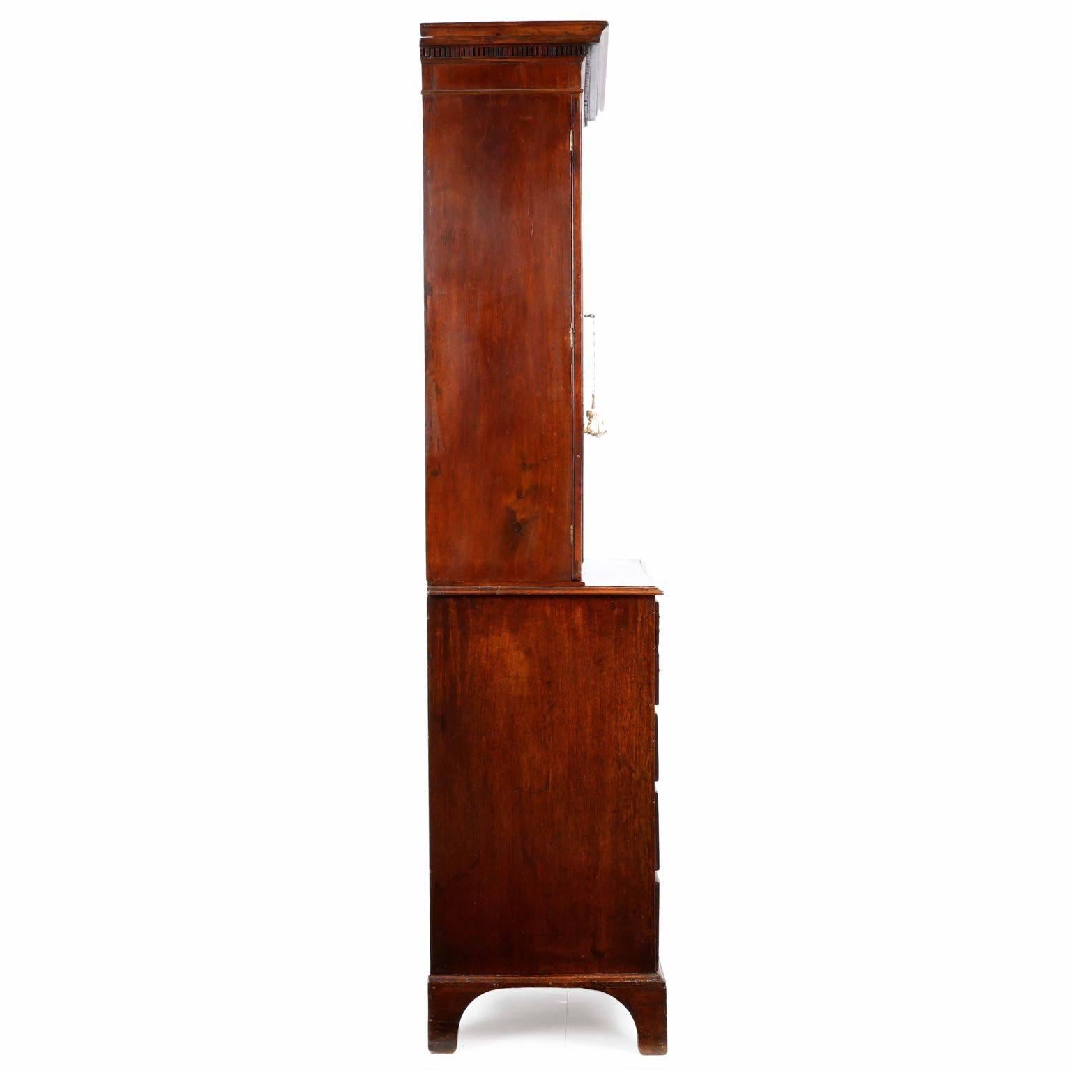 Of perfect size and proportions, this English George III Secretary Desk is commanding in presence while restrained in dimension.  Finely crafted in every way, the piece exhibits bold toothed dentil molding beneath the projecting crown molding over