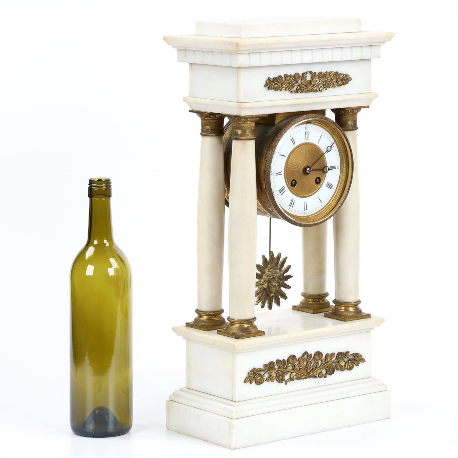 With tasteful embellishments of doré bronze mounts on the pure alabaster surface, this Charles X mantel clock is restrained and most attractive.  The time piece is distinctly architectural in form, a piece inspired by the classical Greek structures