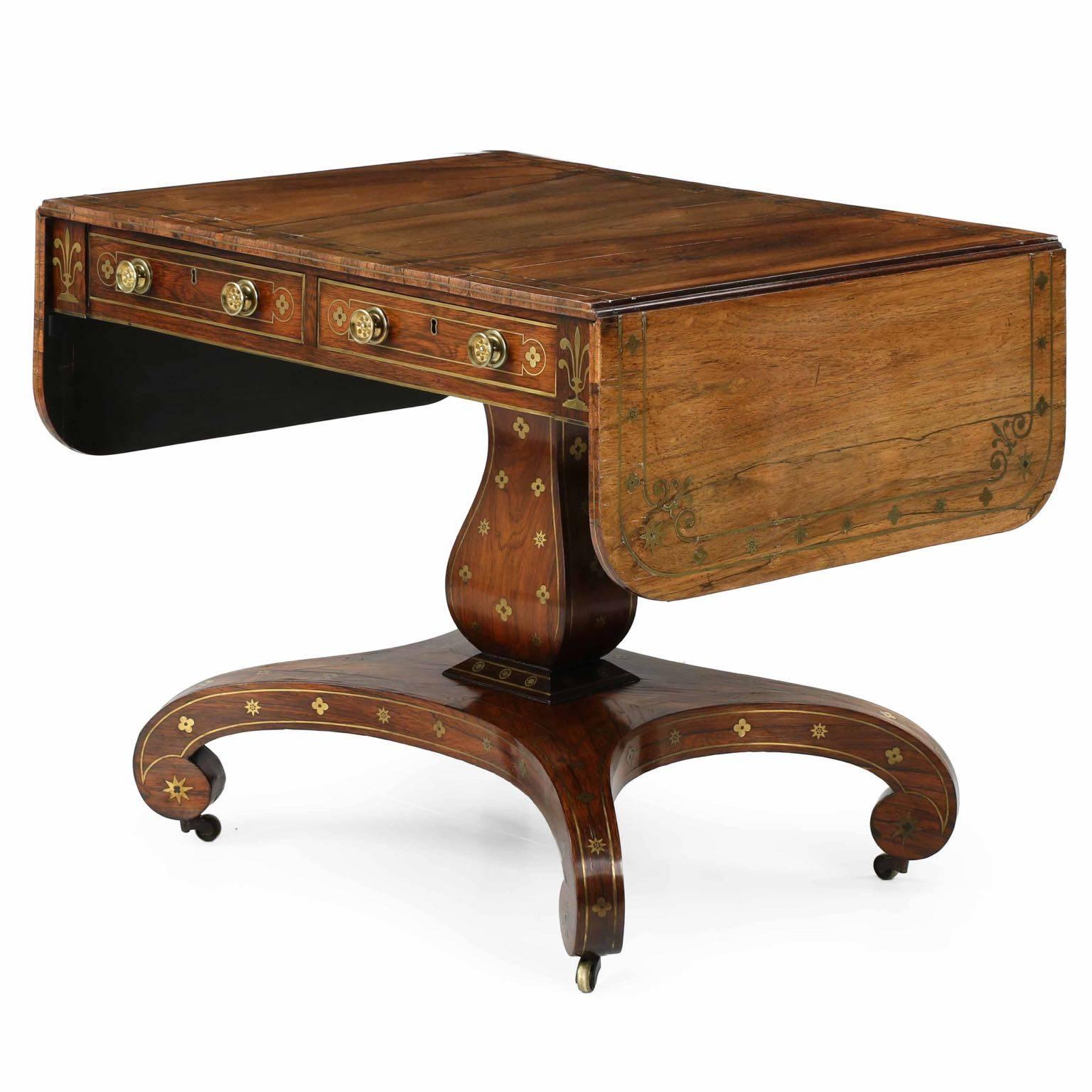 Being a simply superb example of the best quality during the period, this exceedingly fine English Regency sofa table is crafted with a pure eye for design using the best materials available during the period.  Utilizing the highly coveted and